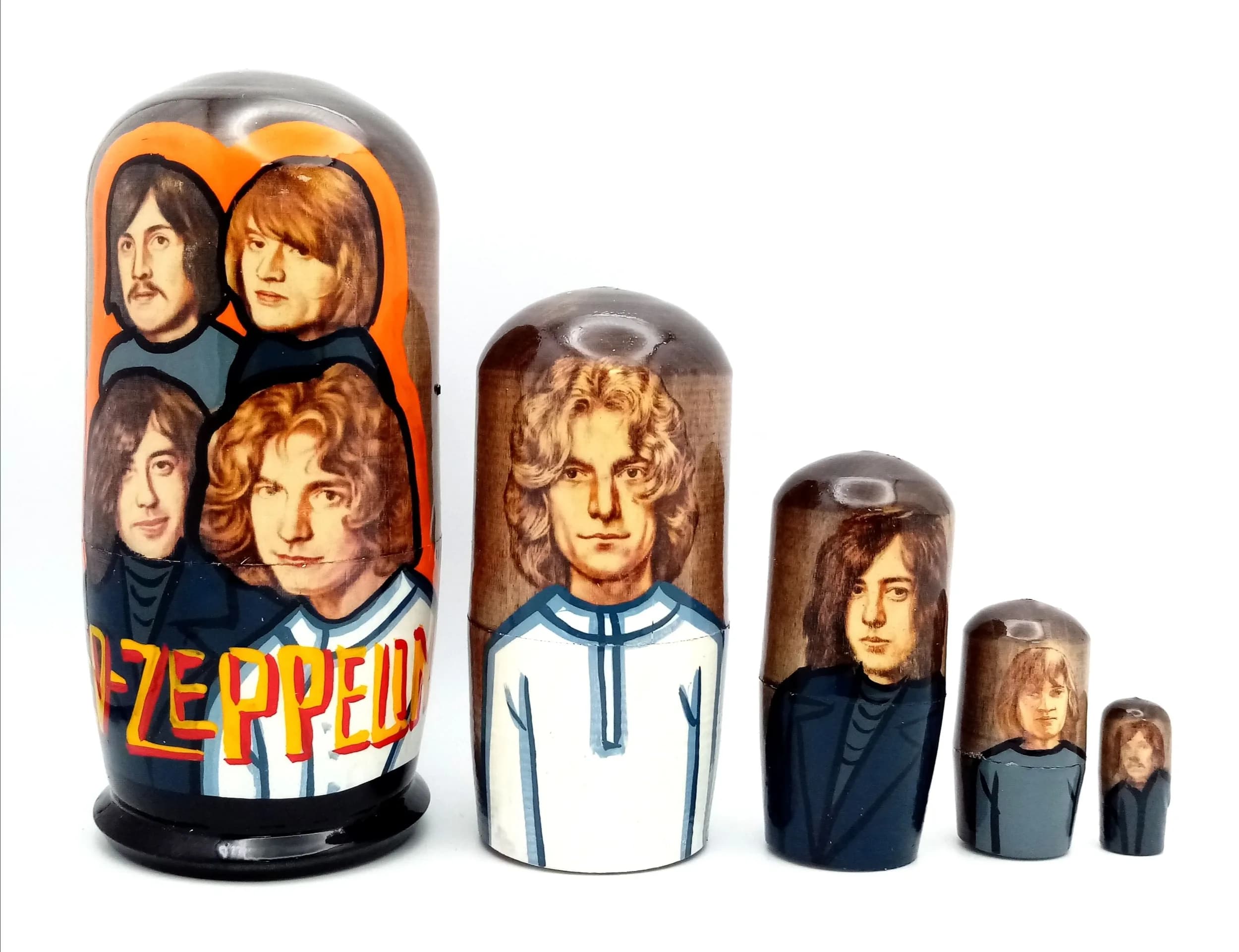A Led Zeppelin Style Russian Nesting Doll Set. Five-piece painted wooden nesting doll set featuring band member portraits. Made in Russia. Tallest doll measures 12cm. All dolls fit inside each other.