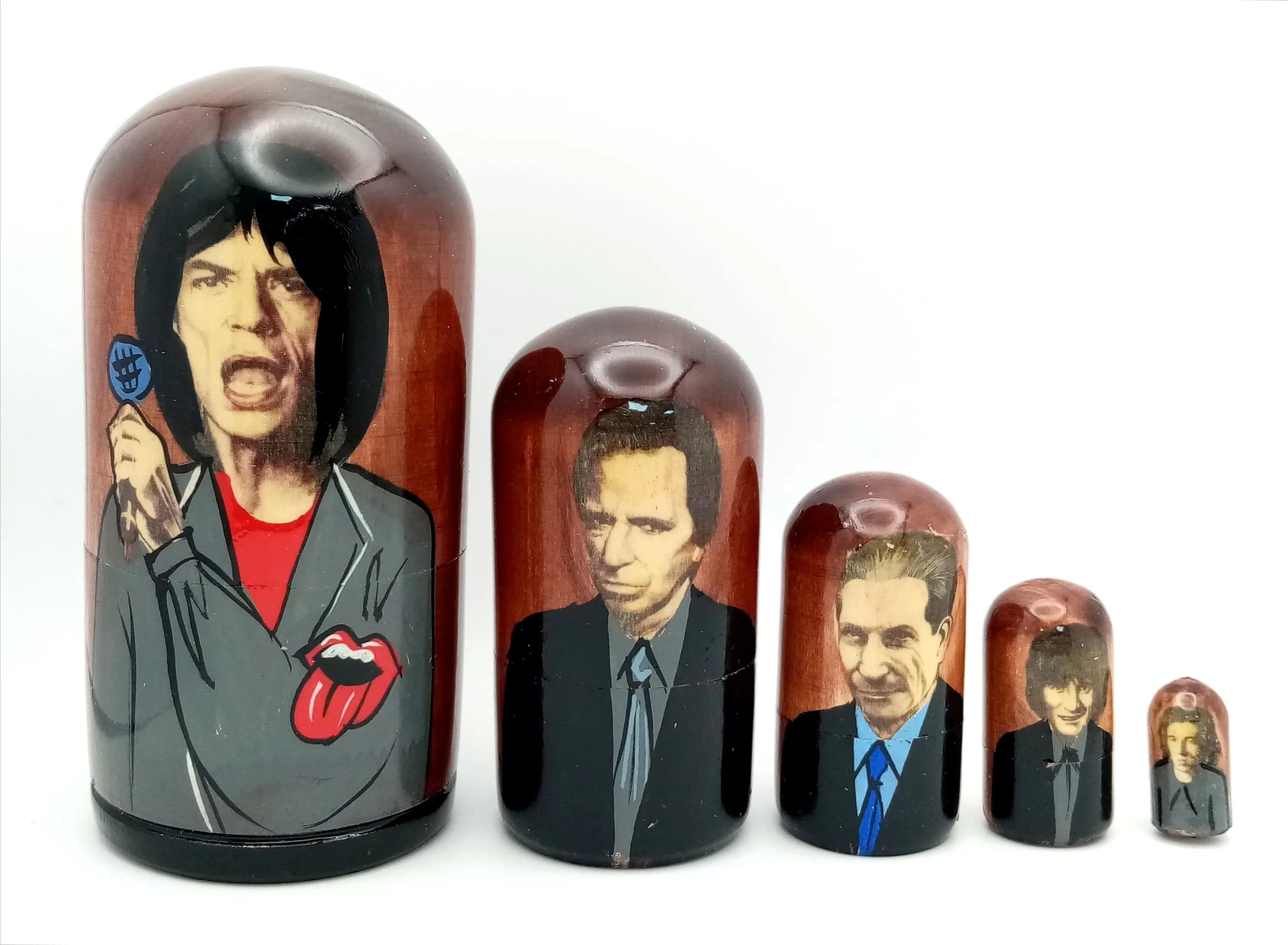 A Rolling Stones Style Russian Nesting Doll Set. Five-piece painted wooden nesting doll set featuring rock band-style figures. Made in Russia. Tallest doll measures 11cm. All dolls fit inside each other.