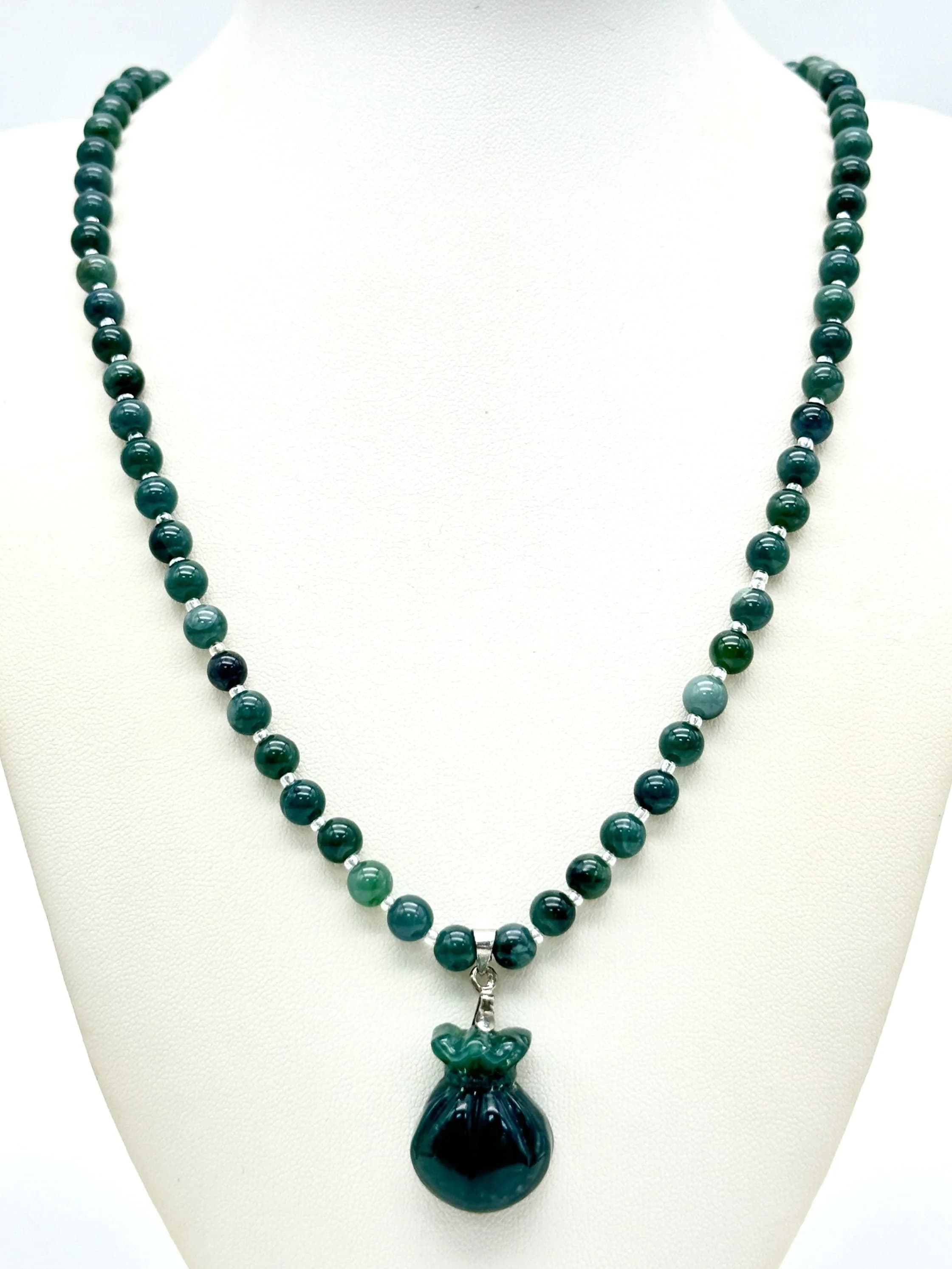 A lovely Green jade Beaded Necklace with a large hand carved bag of gold lucky Pendant. Fitted with a decorative silver tone floral box clasp. Approx 54cm in length. Please see photos for details.