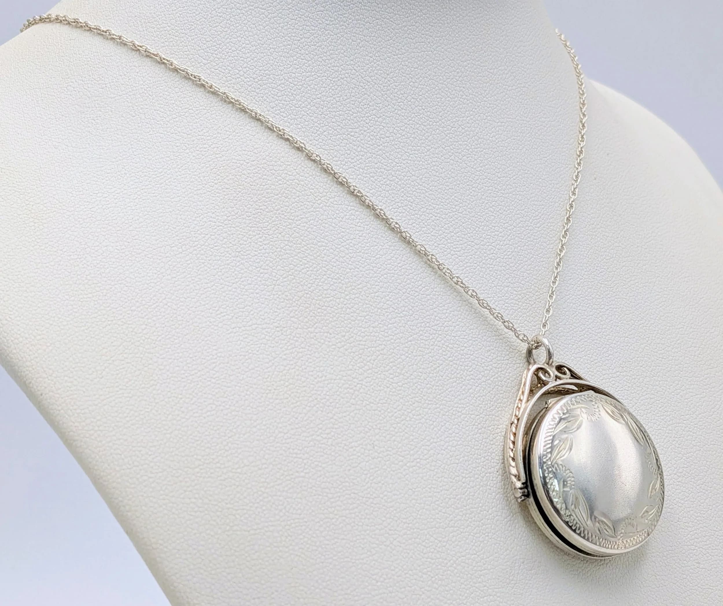 A 925 Silver Spinner Locket Pendant Necklace. Engraved floral decoration. 46cm length necklace. 10.61g total weight.