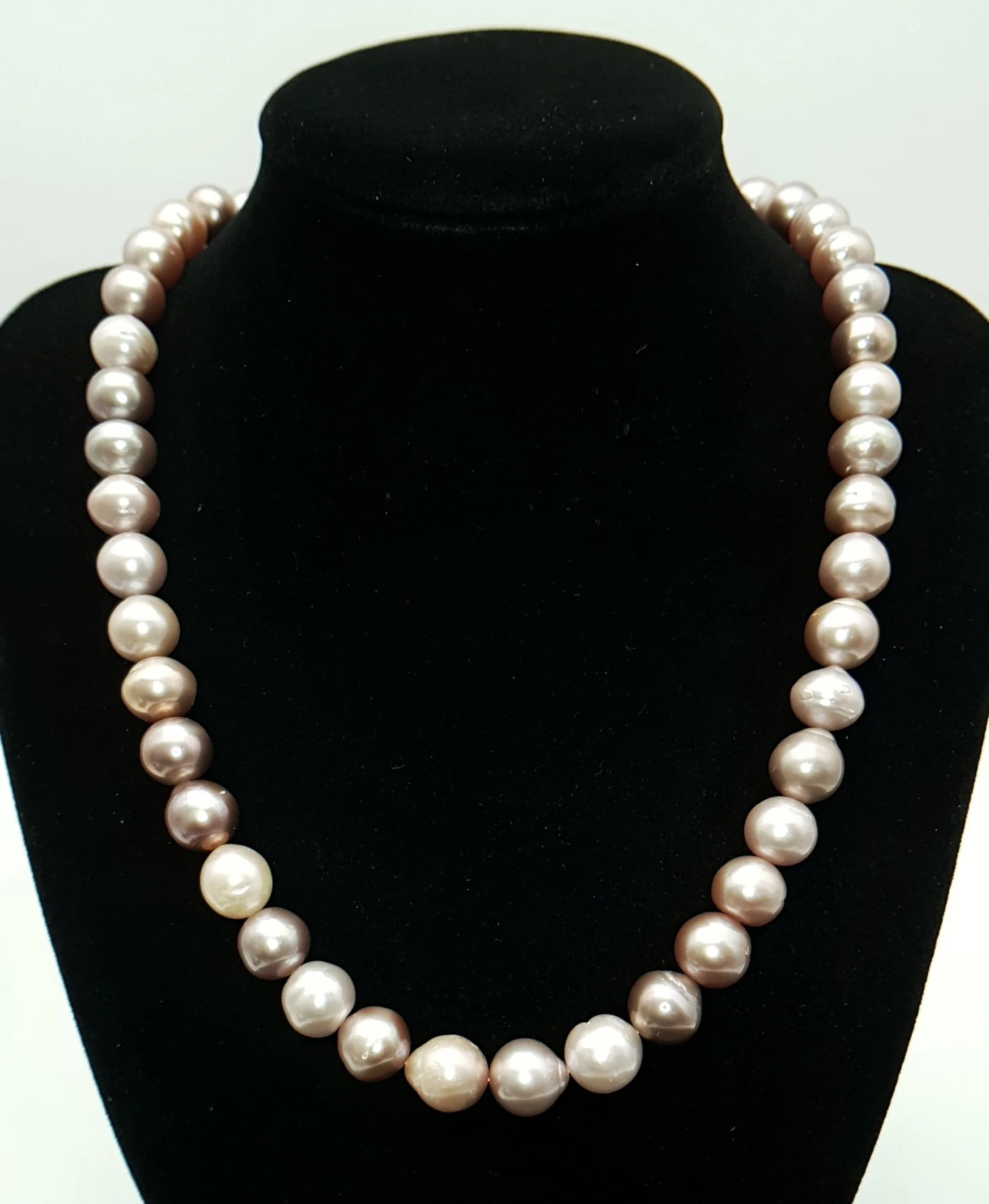 A Very Attractive Single Strand Freshwater Pearl Necklace with large and soft lustre pearls, finished with a decorative infinity-style clasp set with cluster white stones. Approximate length: 48.5cm. Pearl-ranging from 8-11 mm approx. Please see photos for details.