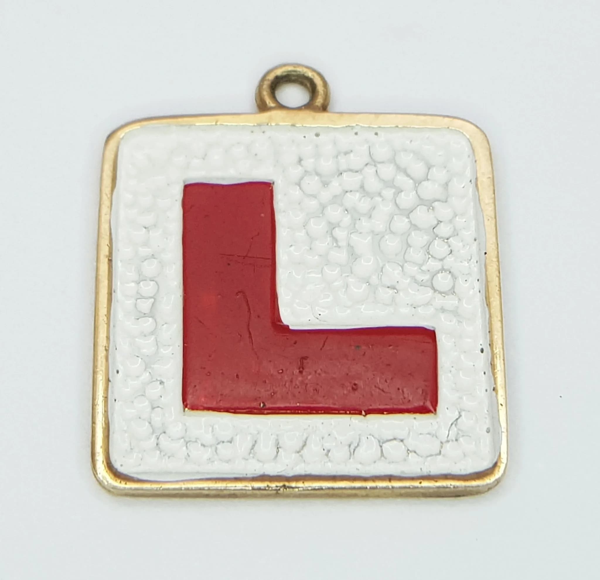 A 9K YELLOW GOLD, ENAMELLED, LEARNER DRIVER PLATE, CHARM / PENDANT. NEEDS A JUMP RING. 1.9G. SC 5040