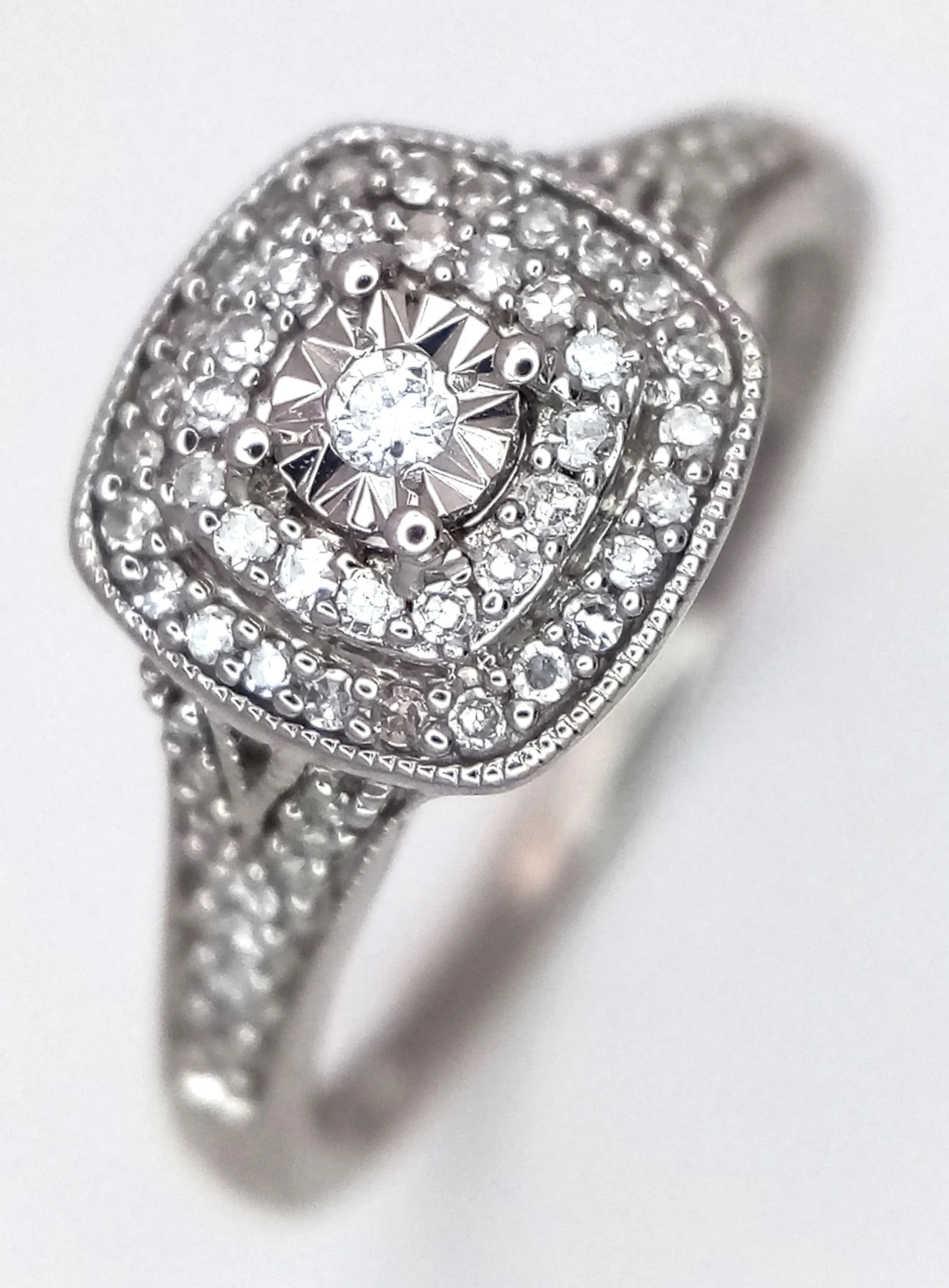 A 9K WHITE GOLD, DIAMOND SET, HALO DESIGN RING. 0.20CTW. 2.4G, SIZE M. SC 5026
