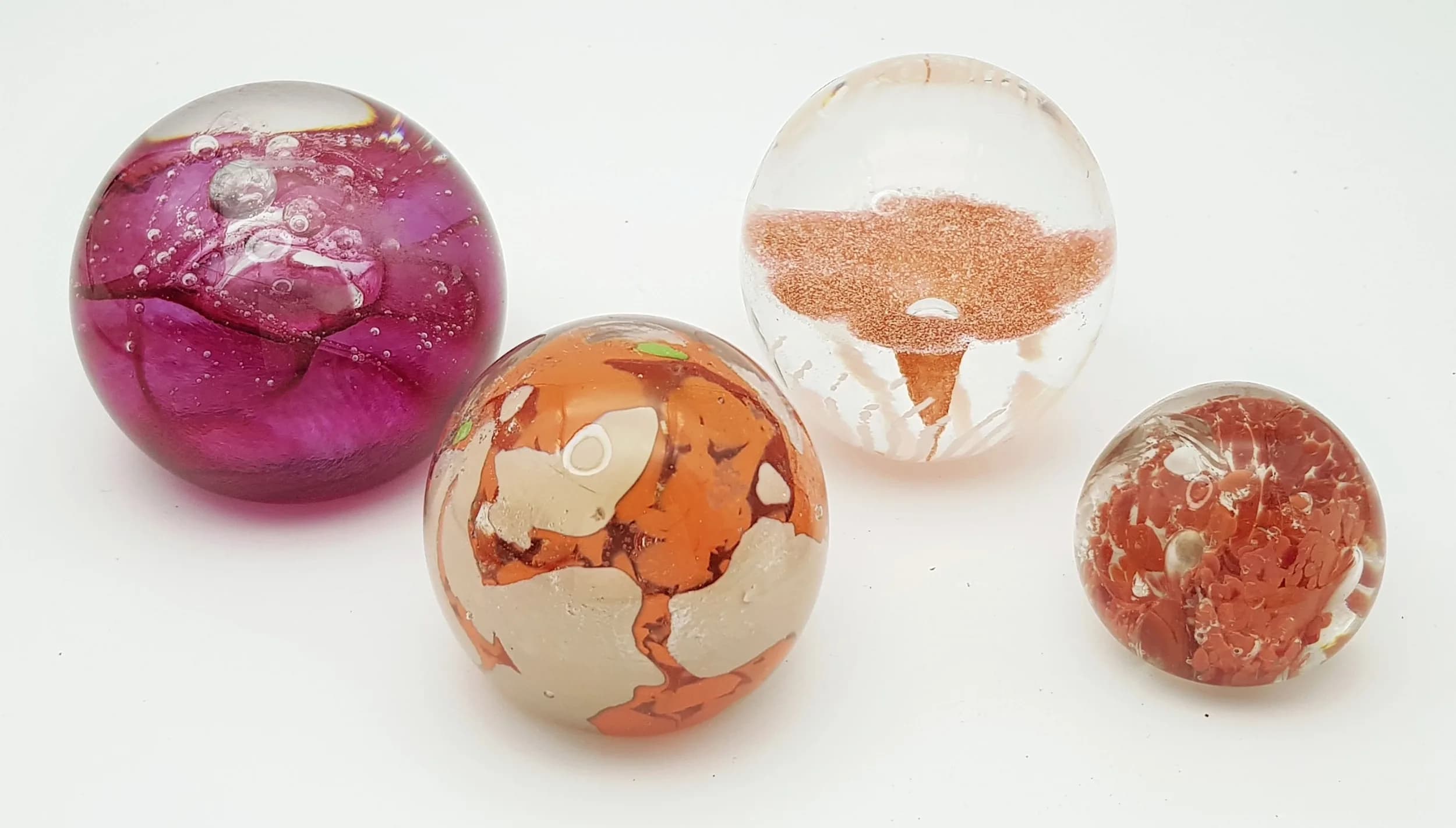 Four Branded Vintage Glass Paperweights: Mallorca, Midana, Caithness and T.V.G.