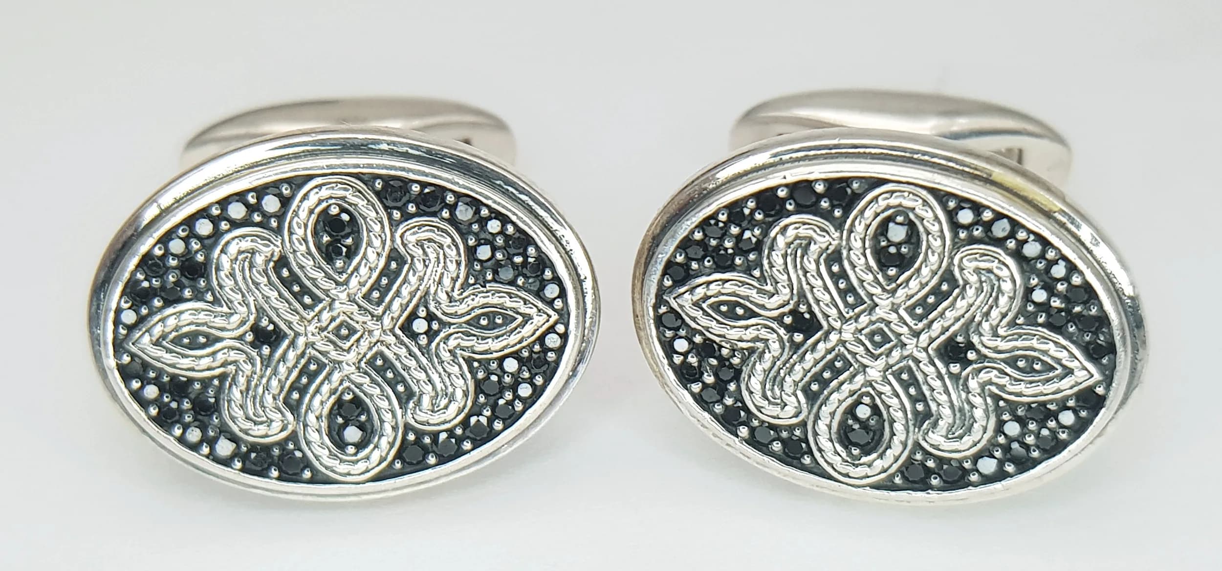 A PAIR OF THOMAS SABO, STERLING SILVER, LOVE KNOT CUFFLINKS. SET WITH BLACK ZIRCONIAS. 18G. TREV SIL 5001