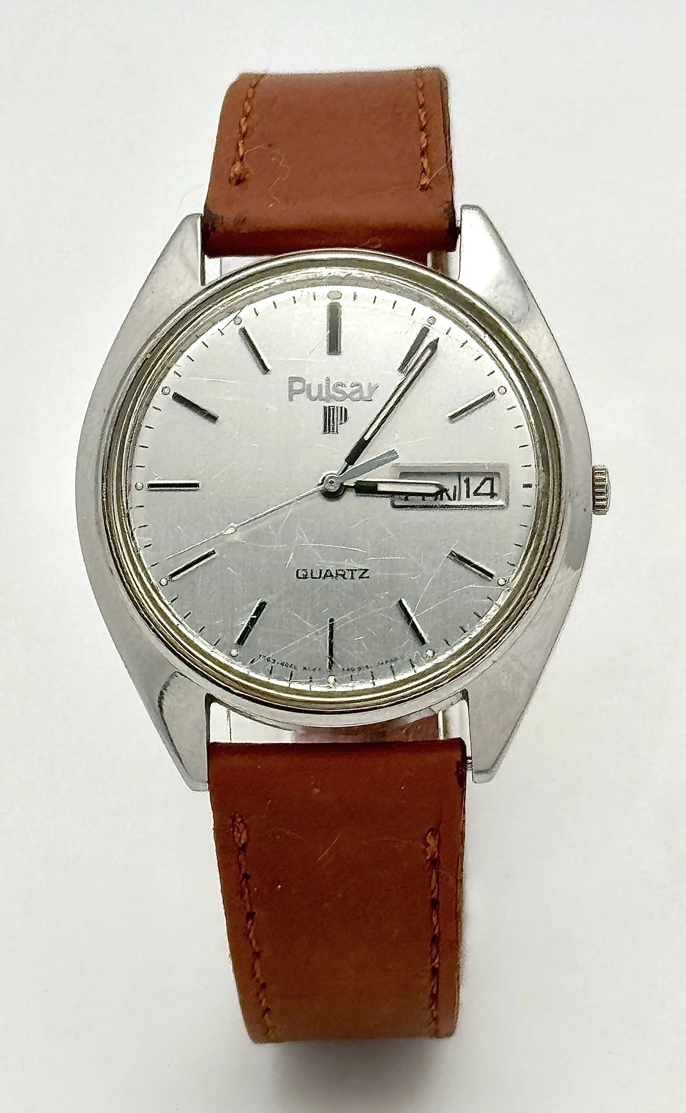 A Vintage Pulsar Quartz Watch. Brown leather strap. Stainless steel case - 36mm. Silver tone dial with day/date window. New battery recently fitted - in working order.