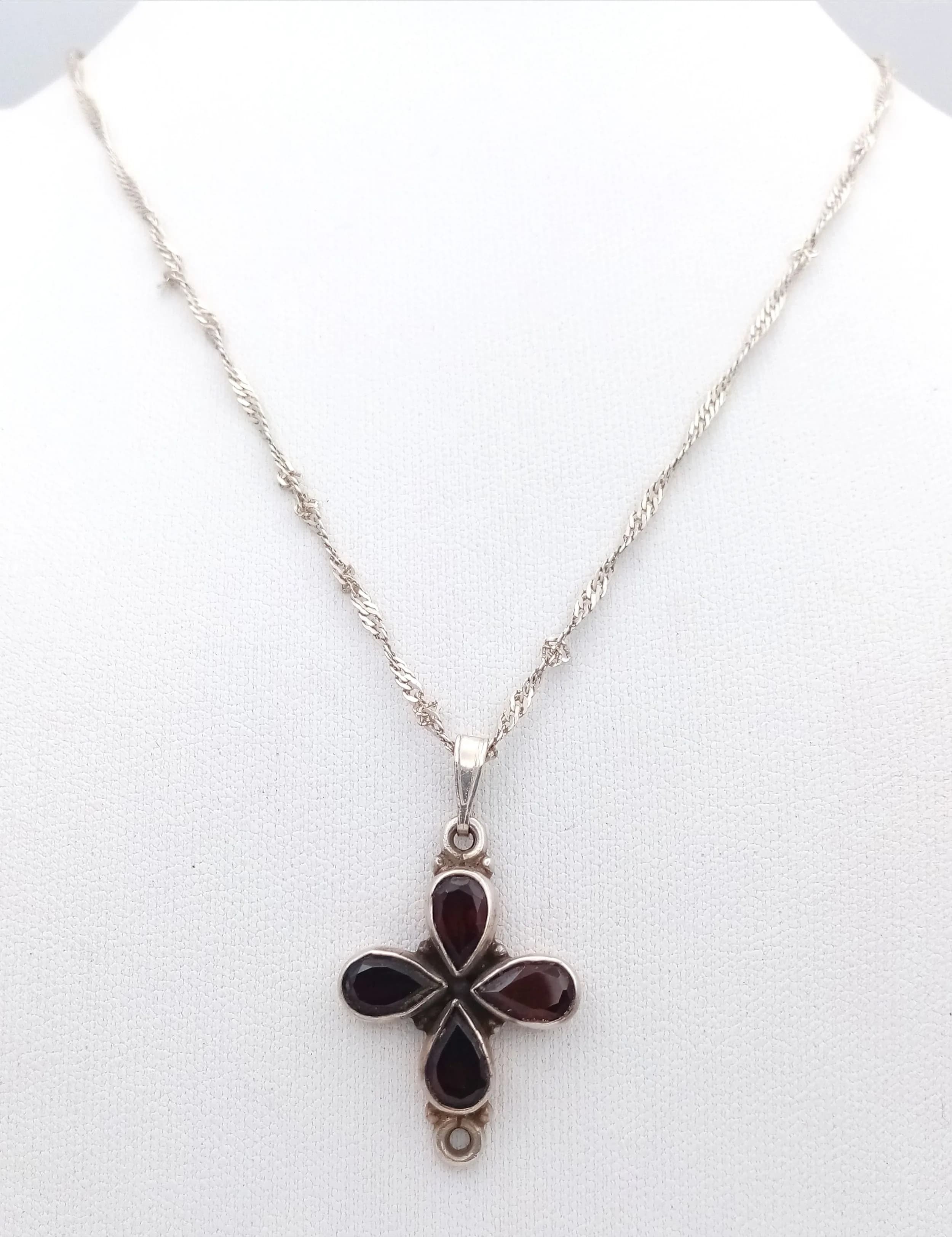 A Pretty 925 Sterling Silver Garnet Flower Pendant Necklace - 46cm Length. Features a flower-shaped pendant set with four pear-cut red garnets on a fine silver chain. The pendant measures 2cm x 2cm. Gross weight 5.33 grams.