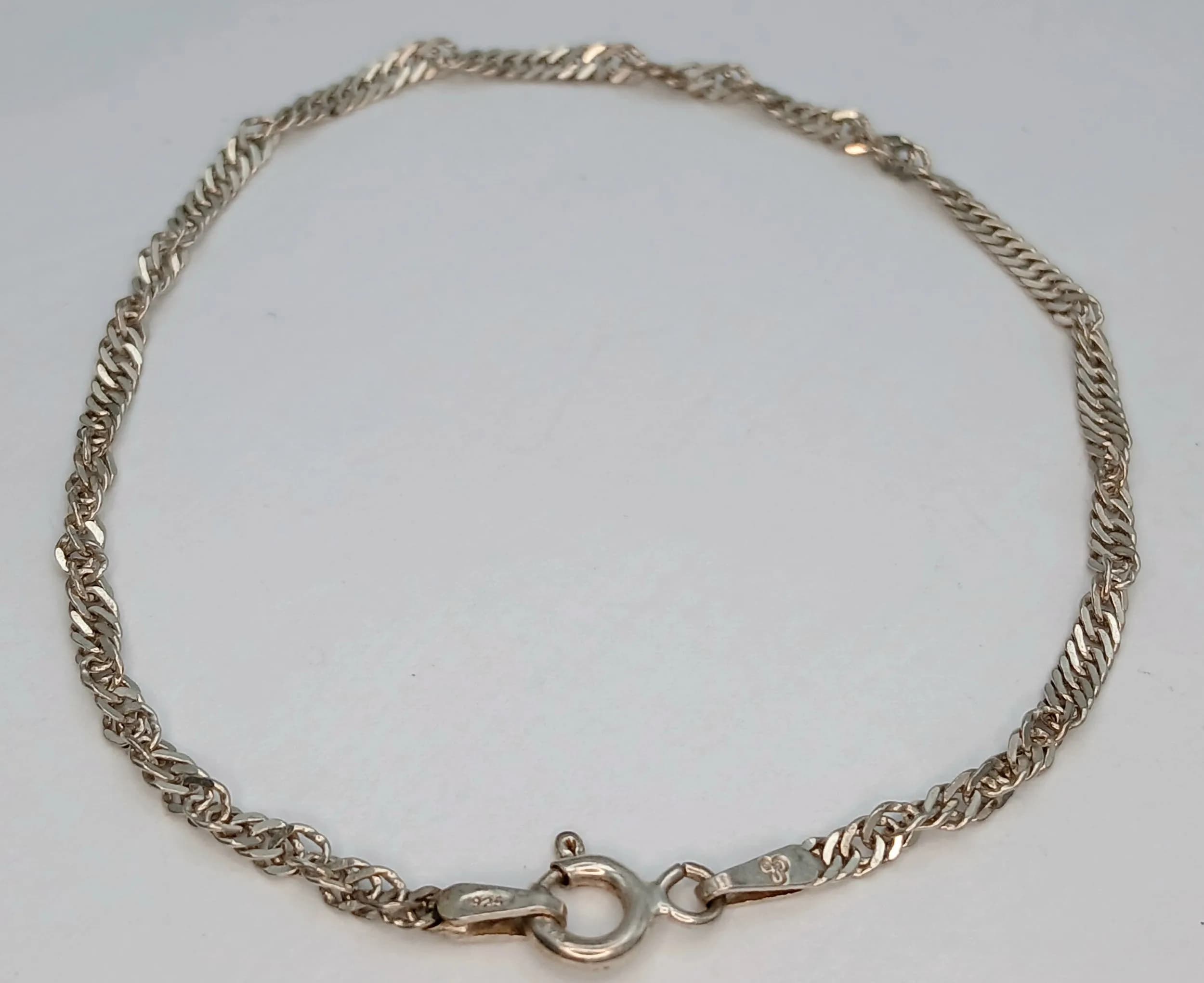 A Pretty Italy 925 Silver Twist Link Bracelet. Features a twisted rope link design with polished bead spacers and a spring ring clasp fastening. The bracelet measures 18cm length. Gross weight 1.71g.
