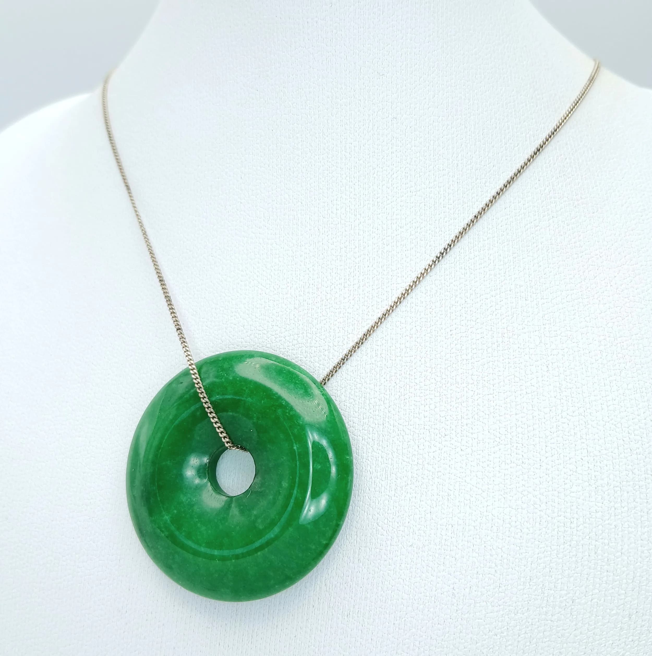 A Green Jade Doughnut Pendant on a 925 Silver Chain. 3.5cm and 44cm.