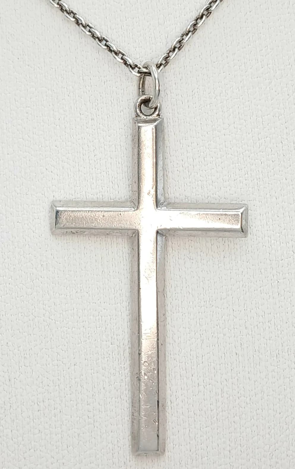 A Pretty 925 Sterling Silver Cross Pendant Necklace - 60cm Length. Features a polished plain cross pendant on a fine curb link chain. The pendant measures 4.5cm x 3cm. Gross weight 9.72 grams.