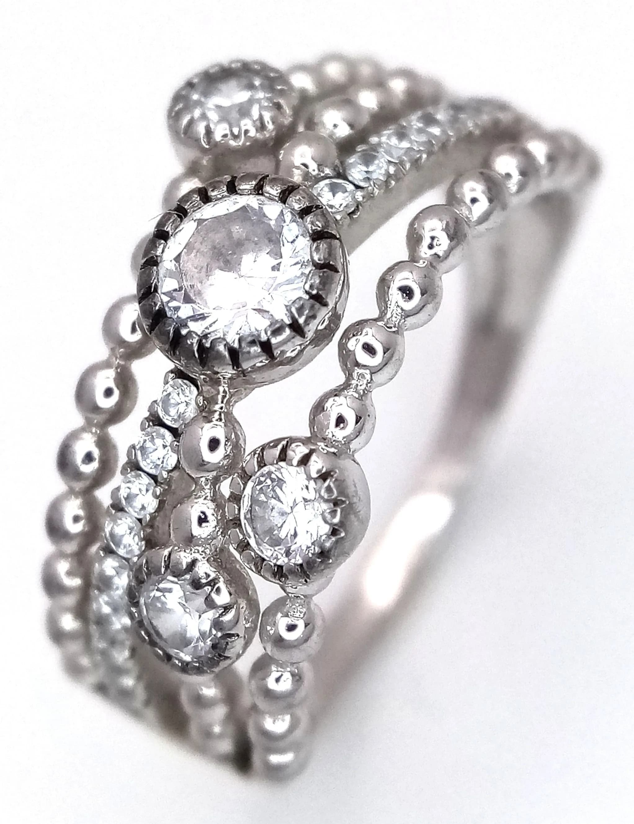 An Eye-catching 925 Sterling Silver White CZ Crossover Ring. Size N 1/2. Features a triple crossover design pavé set with sparkling white CZ stones. Gross weight 3.70 grams.