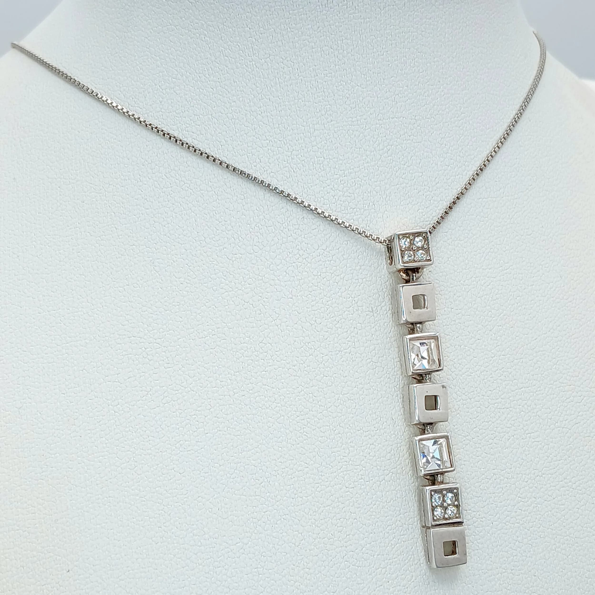 A Stunning 925 Sterling Silver CZ Set Geometric Pendant Necklace - 40cm Length. Features a contemporary geometric pendant with alternating polished and CZ set square links on a fine box chain. The pendant measures 5cm drop. Gross weight 6.83 grams.