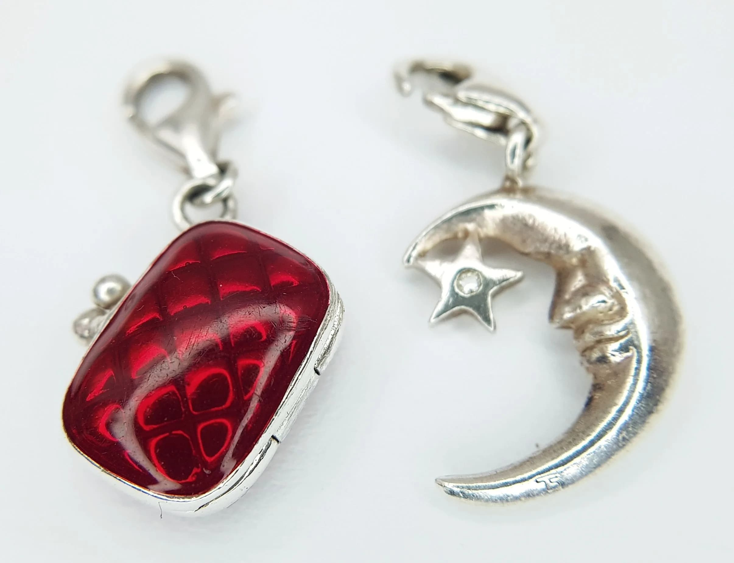 A PAIR OF THOMAS SABO, STERLING SILVER CHARMS. MOON AND STAR AND AN ENAMELLED HANDBAG WHICH OPENS. 5.9G. TREV SIL 6004