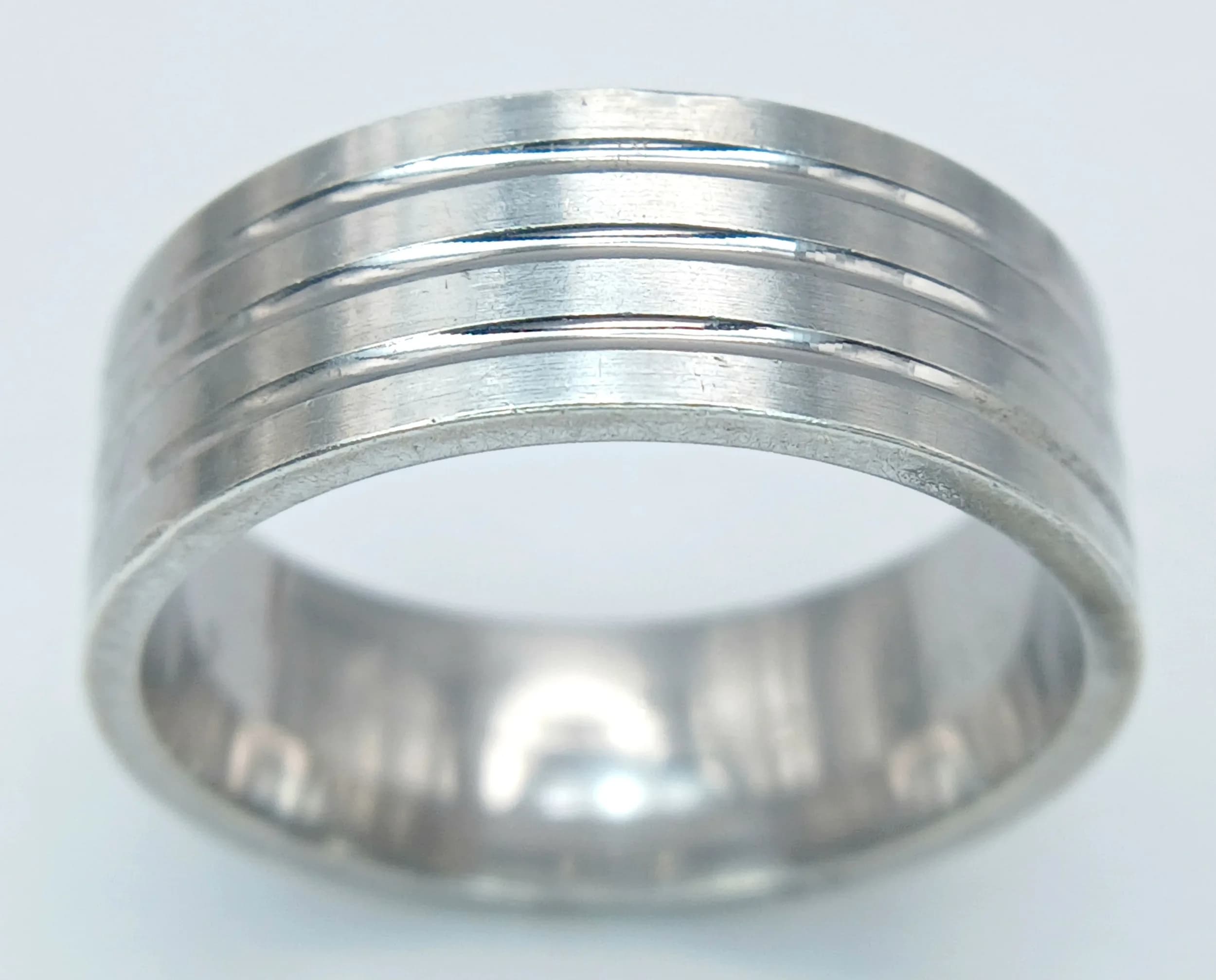 A Stylish Silver Wide Band Ring. Size U. Features a polished wide band with three horizontal engraved grooves encircling the ring. The band measures 0.7cm in width. Gross weight 9.11 grams.
