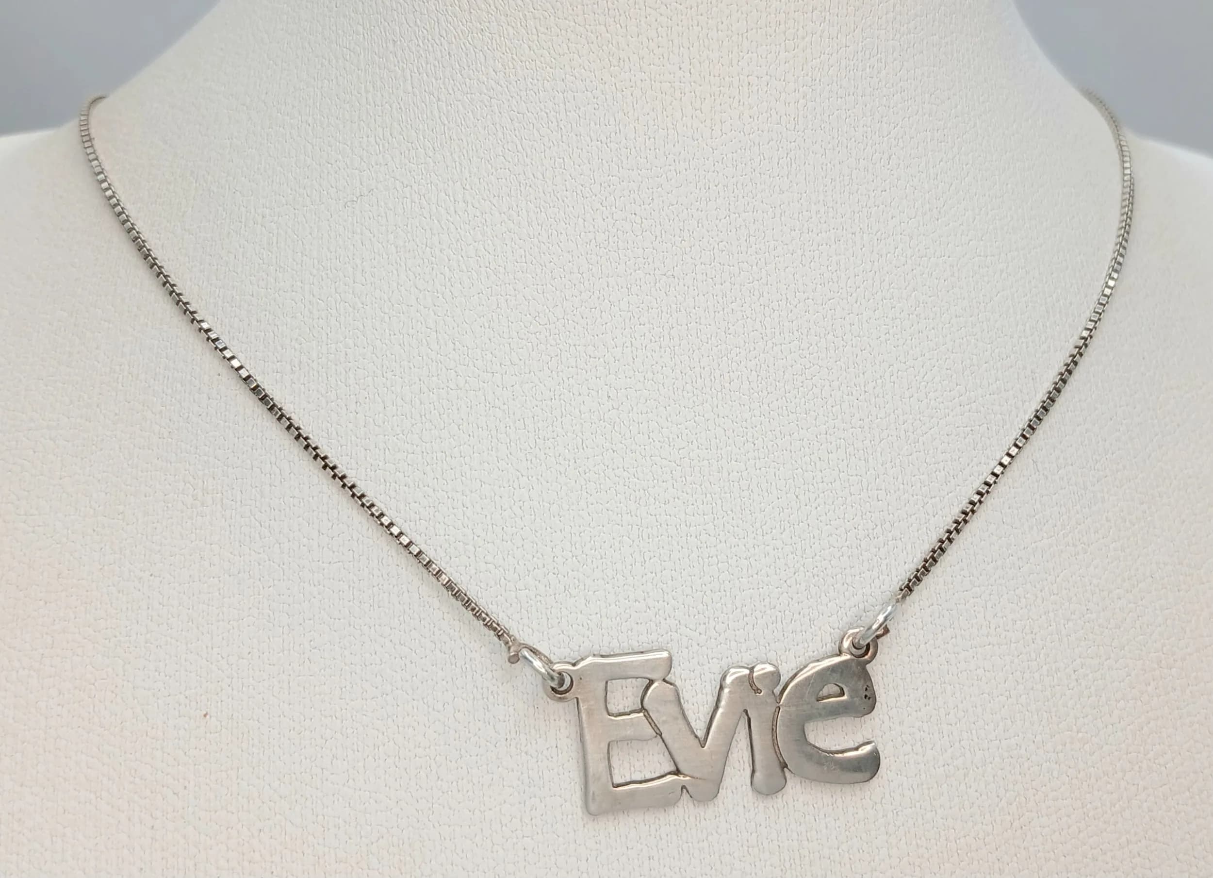 A Stunning Italy 925 Sterling Silver "Evie" Pendant Necklace – 40cm Length. Features the name "Evie" as an integrated script pendant suspended from a fine sterling silver chain. The pendant measures 2.5cm x 1cm. Gross weight 2.91 grams.