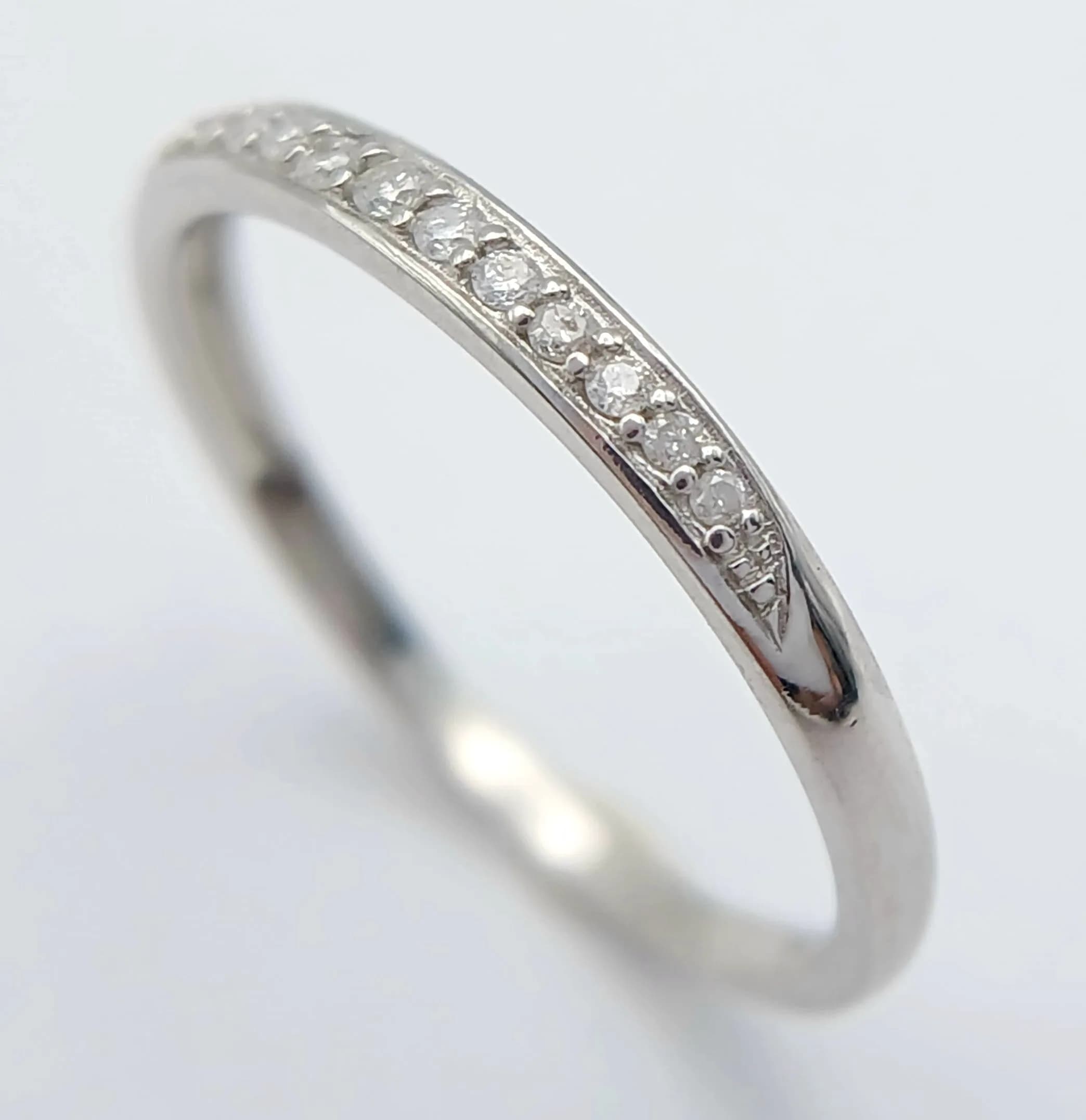 A 9K WHITE GOLD, DIAMOND SET, HALF ETERNITY RING. 1.4G, SIZE K. SC 5009