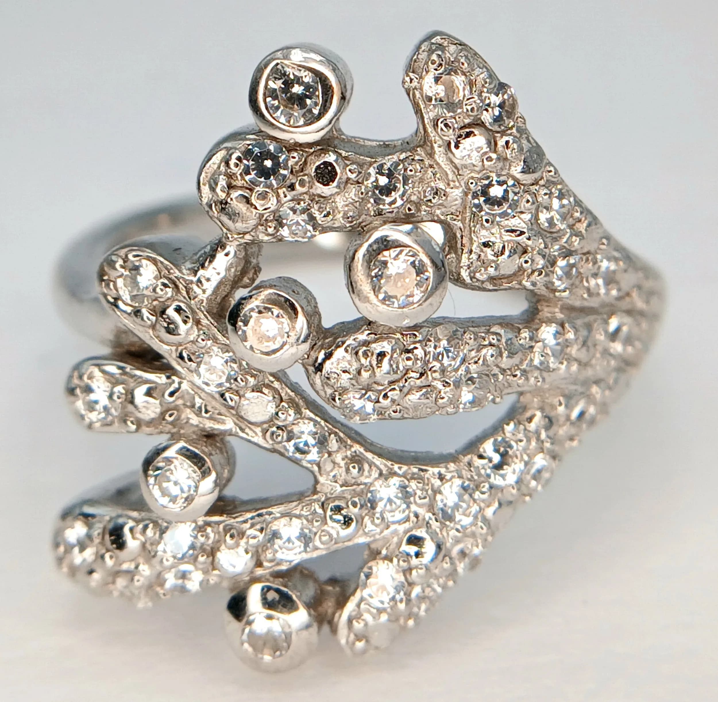A Dazzling 925 Sterling Silver Cubic Zirconia Set Openwork Statement Ring Size N 1/2. The Ring features an abstract layered design set throughout with Round Cut Cubic Zirconia Stones. Gross weight 6.33 grams.