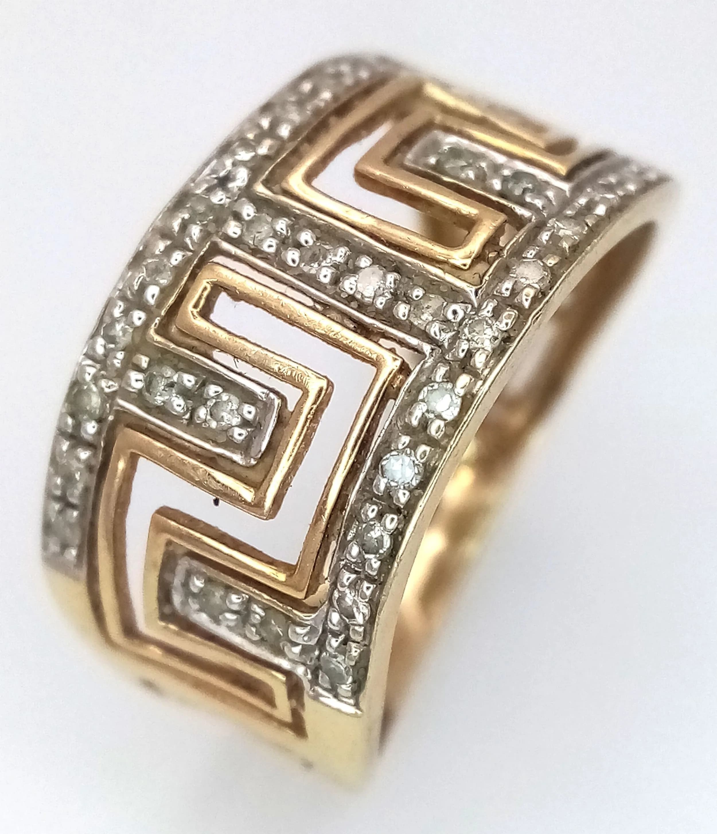 A 9K Yellow Gold and Diamond Band Ring with Geometric Openwork. 11mm widest part. Size N 1/2. 2.6g.