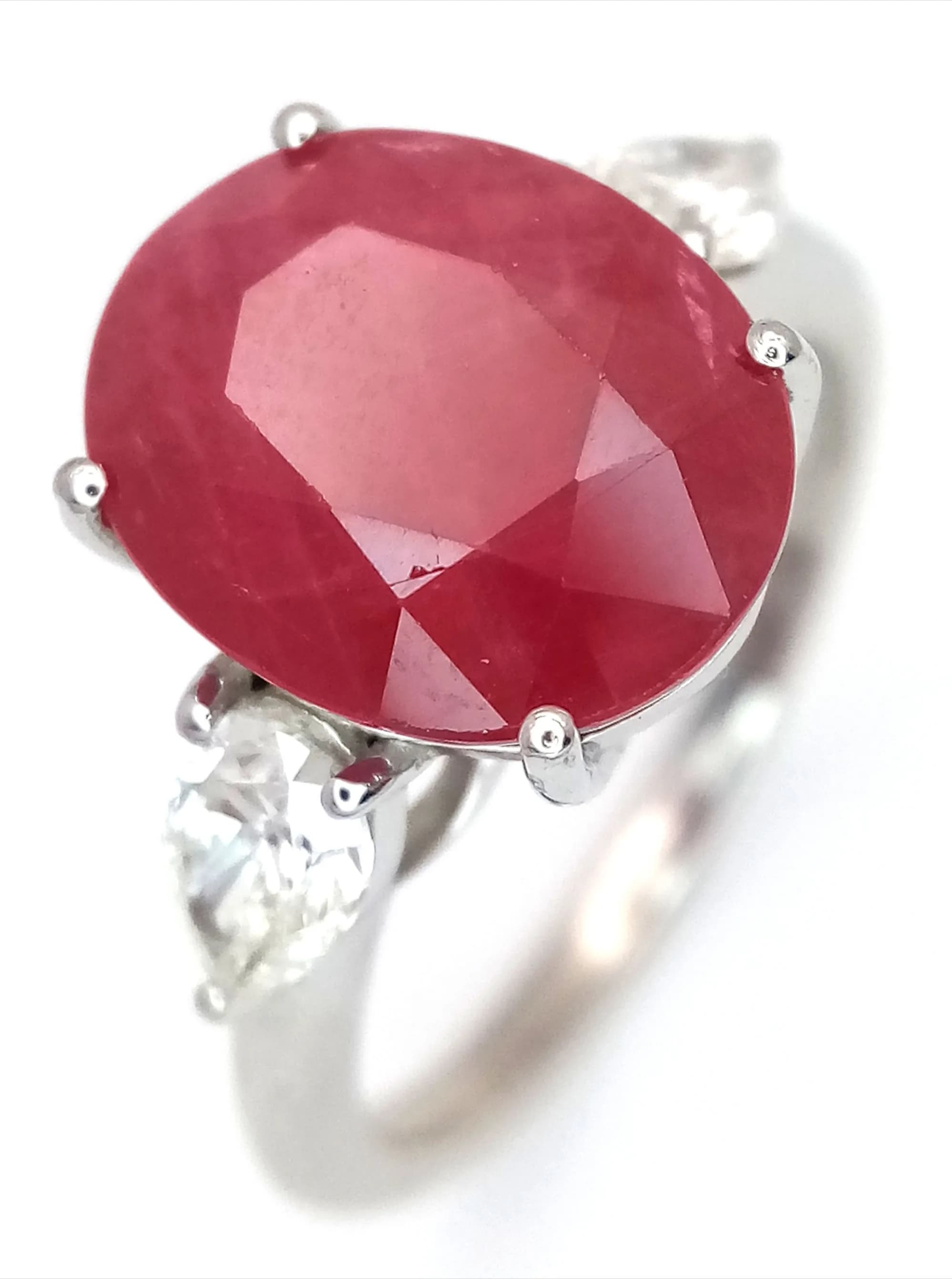 An IGI Certified, 950 Platinum, Ruby and Diamond Ring. A 6.24ct oval mixed cut ruby with two pear brilliant cut diamonds - having I/J colour and SI clarity. Ref: LXR- 90047.