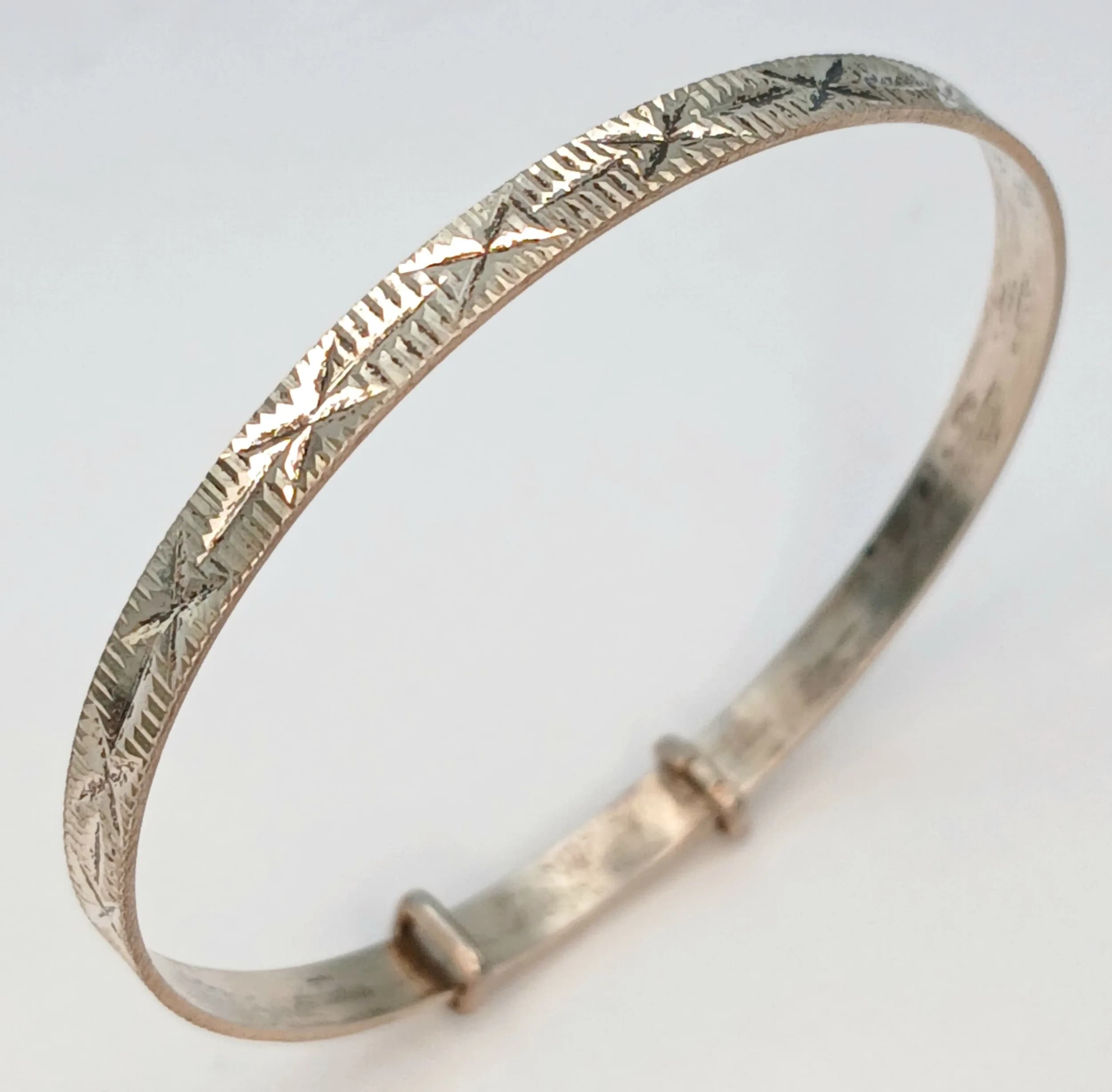 A Vintage Silver Adjustable Baby Bangle. Features a polished band with an adjustable sliding design. The bangle measures approx 4cm diameter with a 0.3cm wide band. Gross weight 2.53 grams.