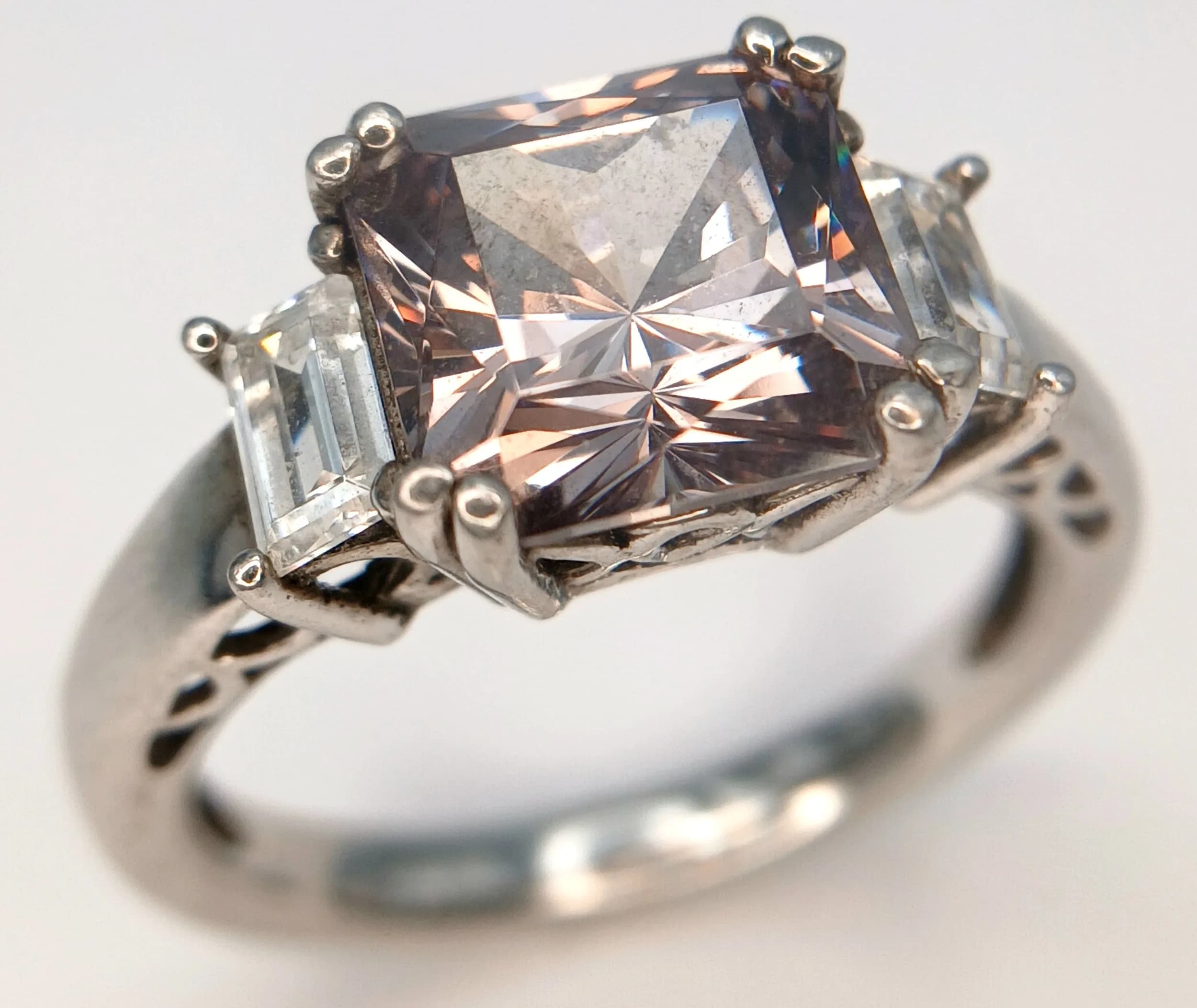 An Eye-catching 925 Sterling Silver Black CZ Stone Ring. Size Q½. Features a square-cut black CZ stone in a four-claw setting, flanked by baguette-cut clear stones to each shoulder. The centre stone measures 0.7cm x 0.7cm. Gross weight 5.31 grams.