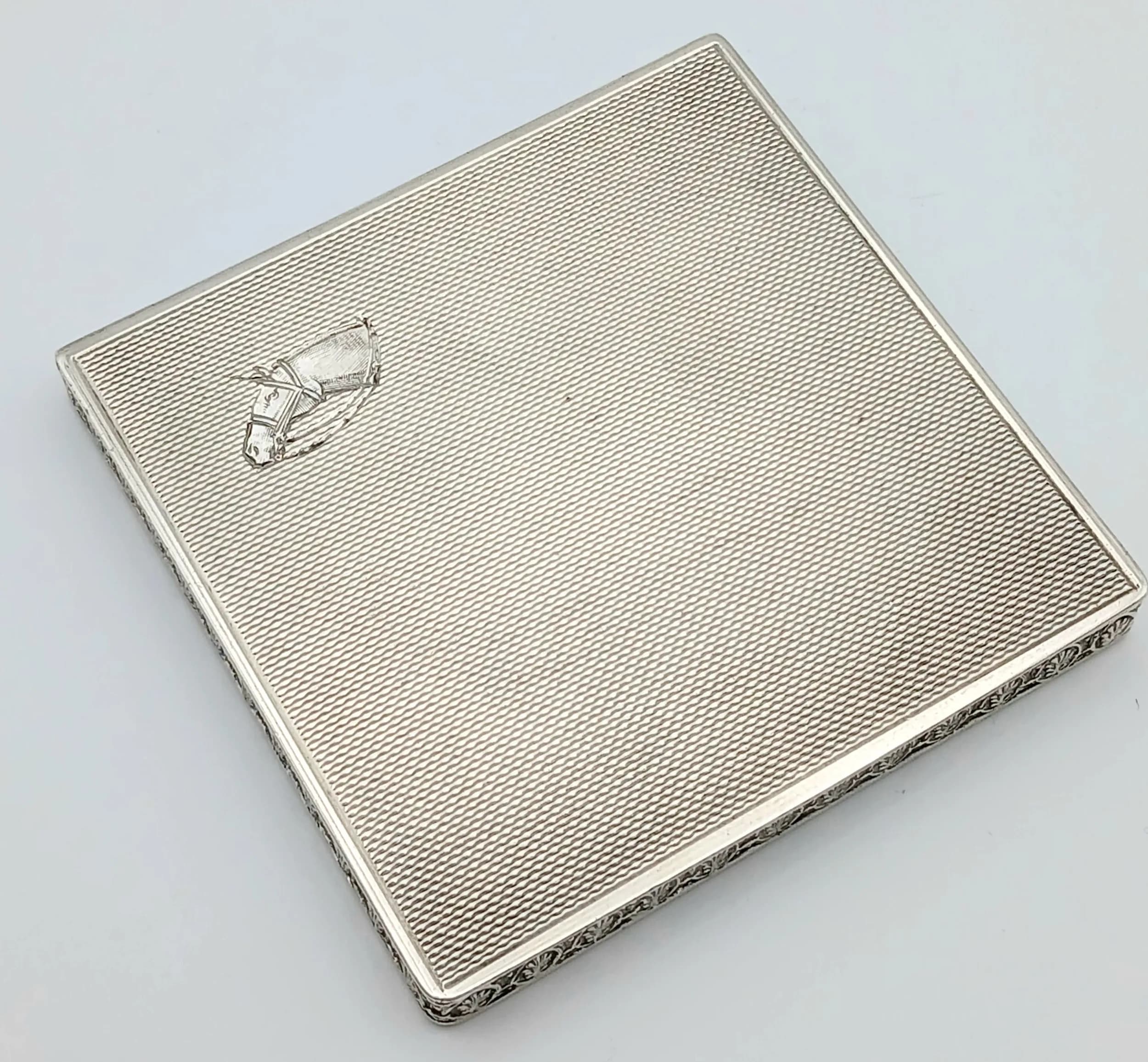 A HALLMARKED SILVER VANITY BOX WITH A HORSE HEAD LOGO . 80gms 7 x 7cms