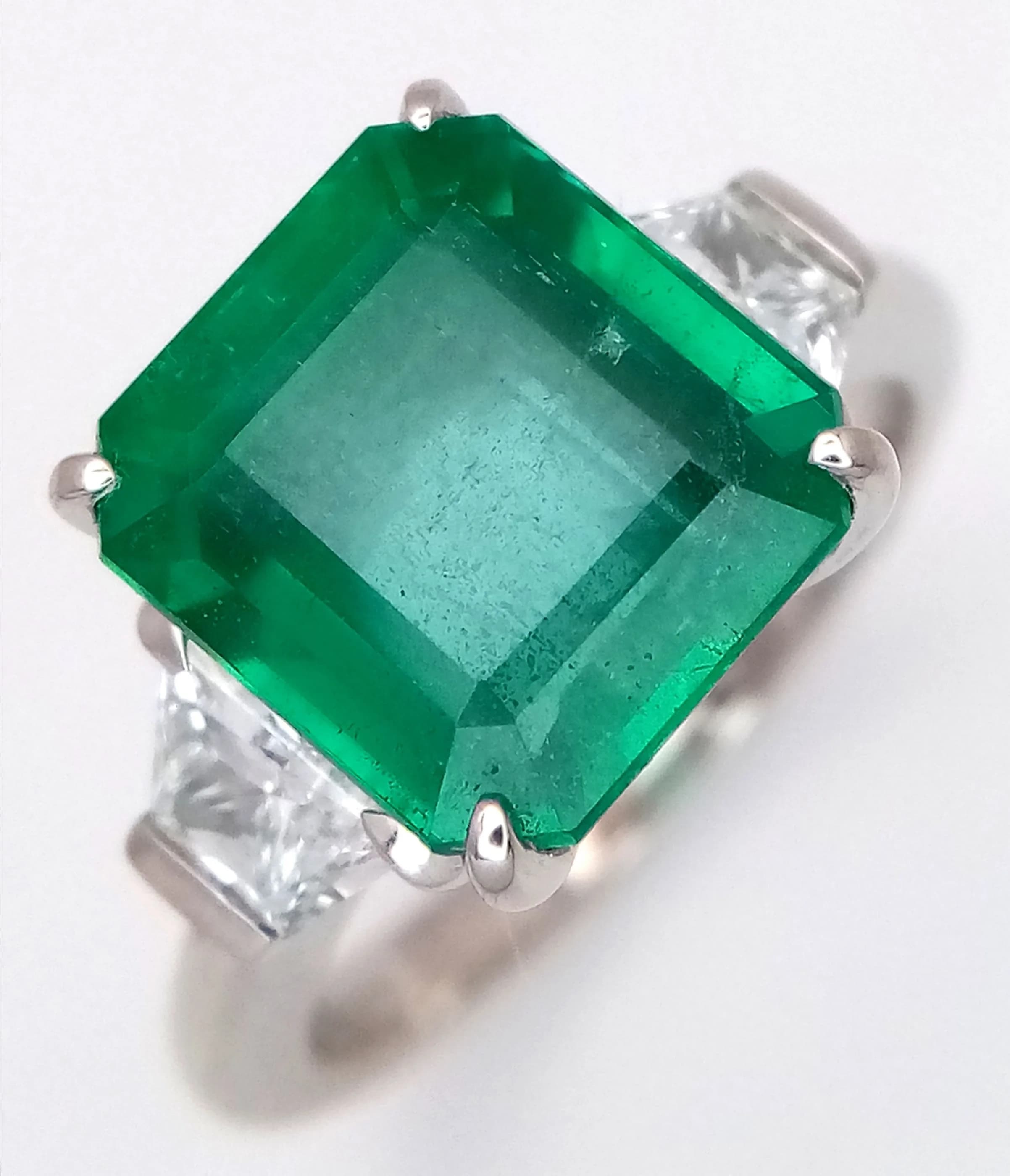 A Triple Certified, 950 Platinum, Emerald and Diamond Cocktail Ring. A 4.84ct GIA certified Zambian Octagonal cut Green Emerald in a claw setting - two GIA certified modified trapezoid cut diamonds on shoulders of 0.60ctw - having D colour and internally flawless/VVS1 clarity. Size N 1/2. 9.1g total weight. Ref: LXR-90010.