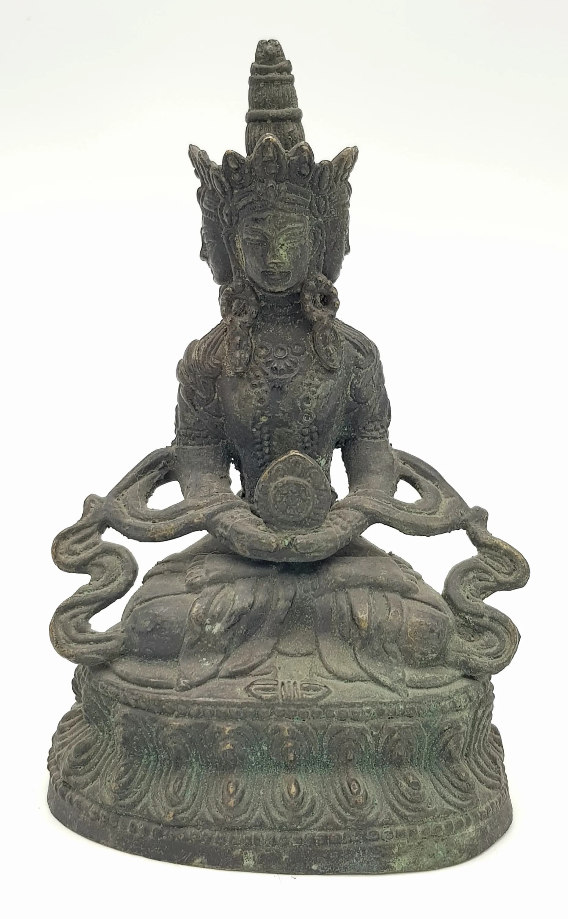An antique Chinese Seated Bronze Buddha in dhyanasana (meditative posture), hands resting in the lap in a gesture of serenity. Draped in flowing monastic robes, thefigure sits atop an unsealed lotus base, symbolizing purity and spiritual awakening.The form is well-proportioned, with a calm and compassionate expression.A piece of devotional significance and aesthetic value, ideal for collectors of Buddhist art orinterior display. Dimensions: Height 18 cm (including finial); Base approx. 11 cm.