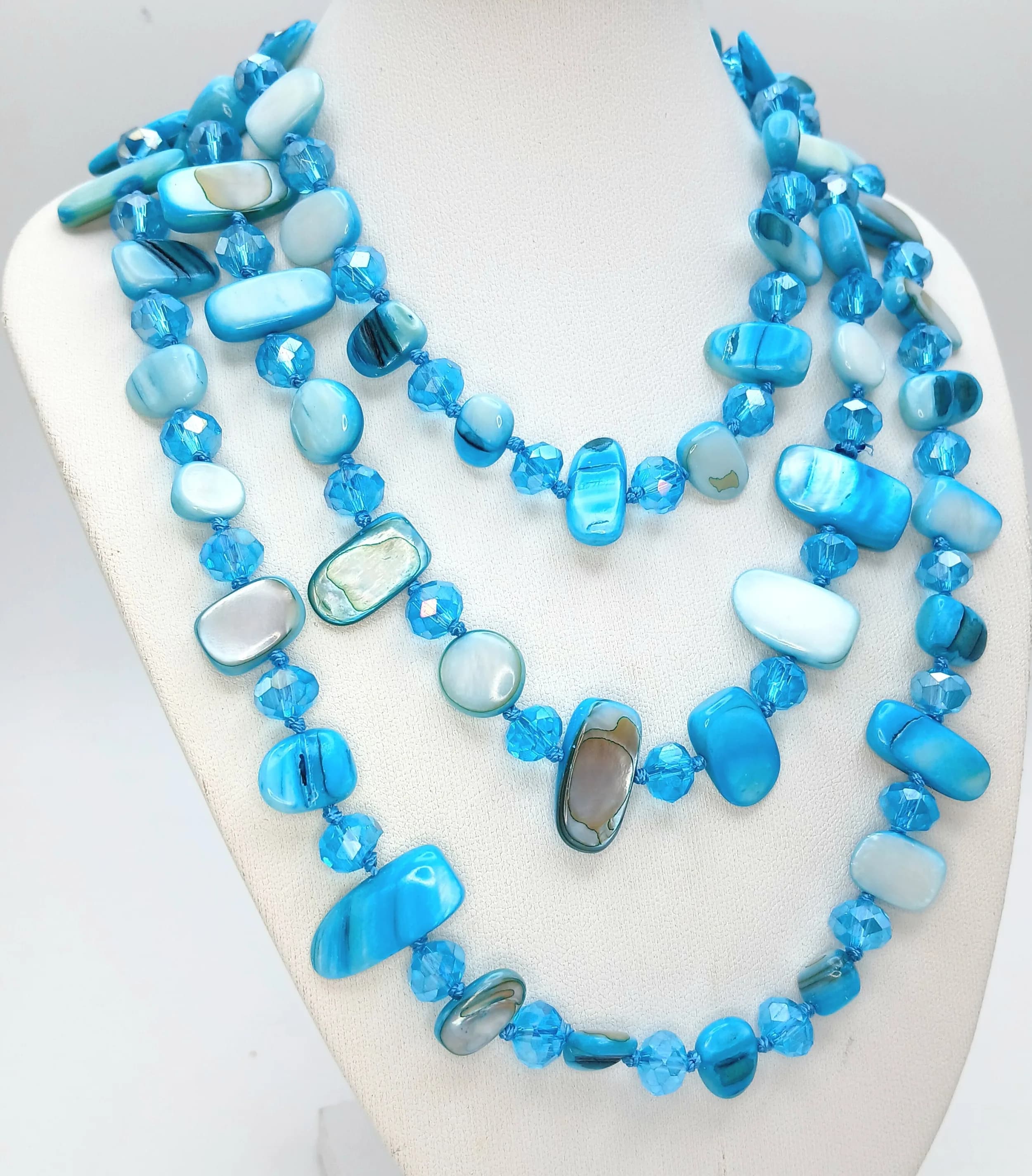 A Very Long Blue Dyed Shell Bead Necklace. Features polished blue dyed shell beads interspersed with faceted blue glass crystal spacer beads. The necklace measures 110cm length.