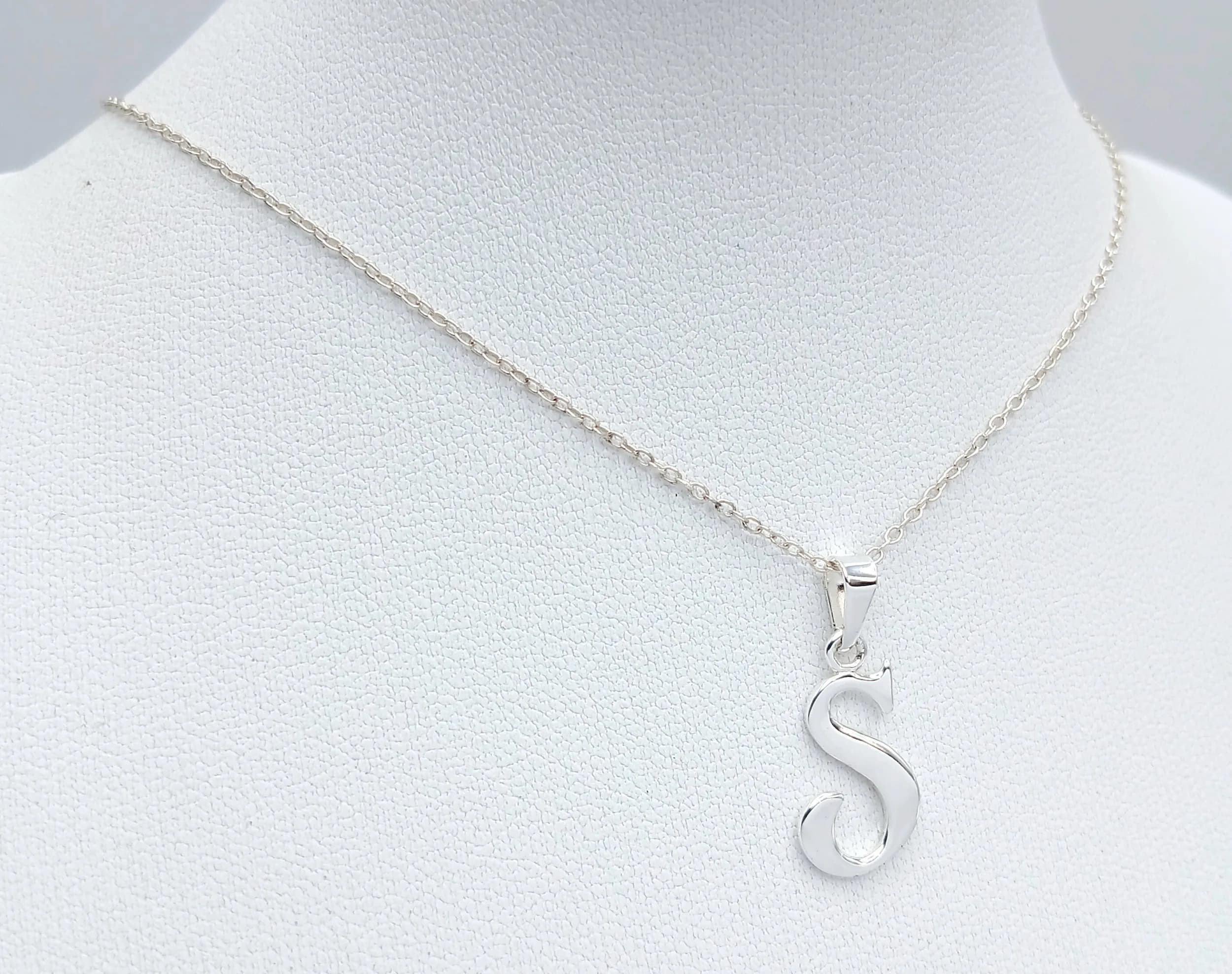 A 925 Silver Necklace with Letter ‘S’ Pendant. Both Necklace and Pendant are Hallmarked 925. Total weight 1.62g. Approx 45cm chain length with a 2cm pendant. Comes with presentation box.
