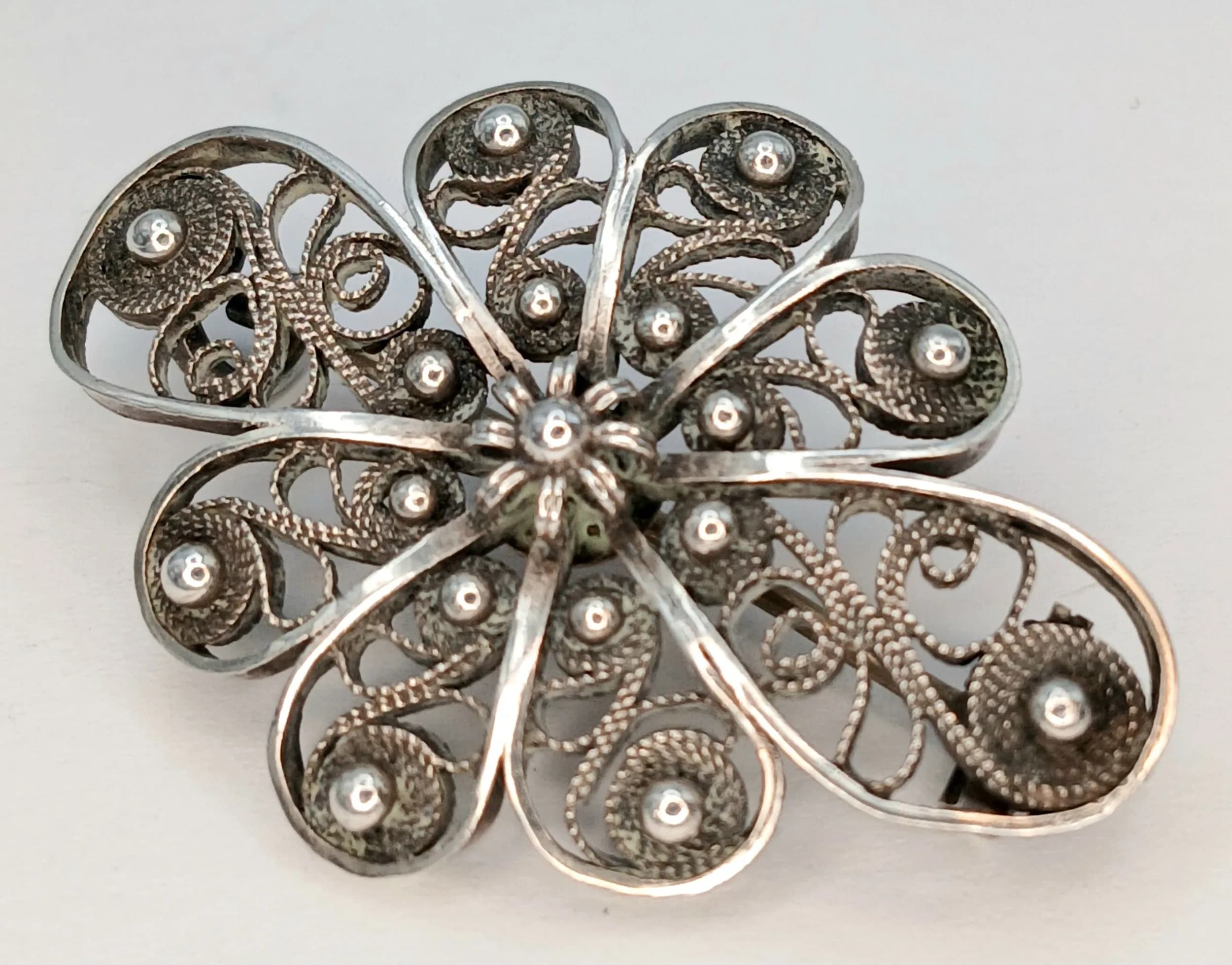 A Beautiful 925 Silver Filigree Flower Brooch. Features an intricate openwork floral design with decorative bead details. The brooch measures 4cm x 3cm. Gross weight 5.18 grams.