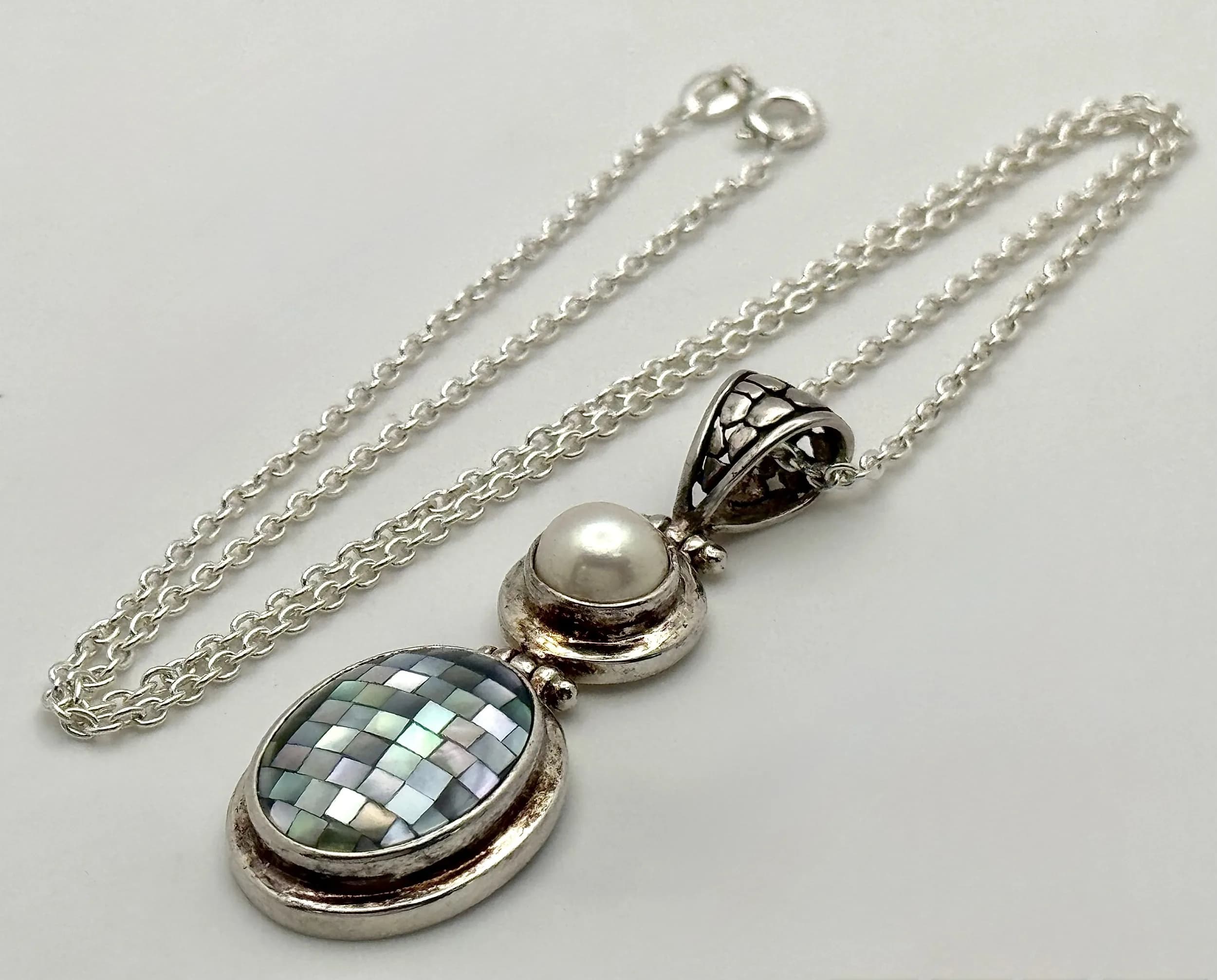 A 925 Silver Pearl and Mother of Pearl Mosaic Pendant Necklace. 5.5cm length pendant, 46.5cm length anchor link chain. 13.06g total weight.