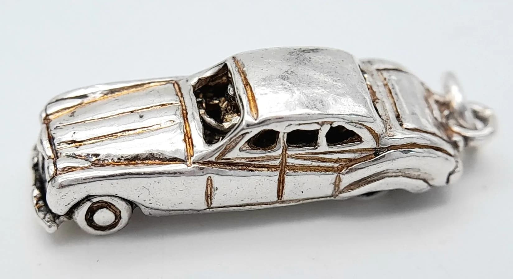 A STERLING SILVER, CAR CHARM, WHICH OPENS. 5G. 8439