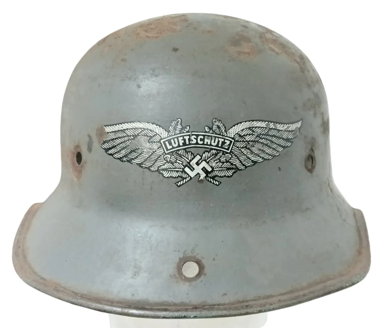 A WW2 German Luftschutz Helmet (air raid police). No Liner. There is an extra hole drilled in the peak that was used for hanging on a hook.