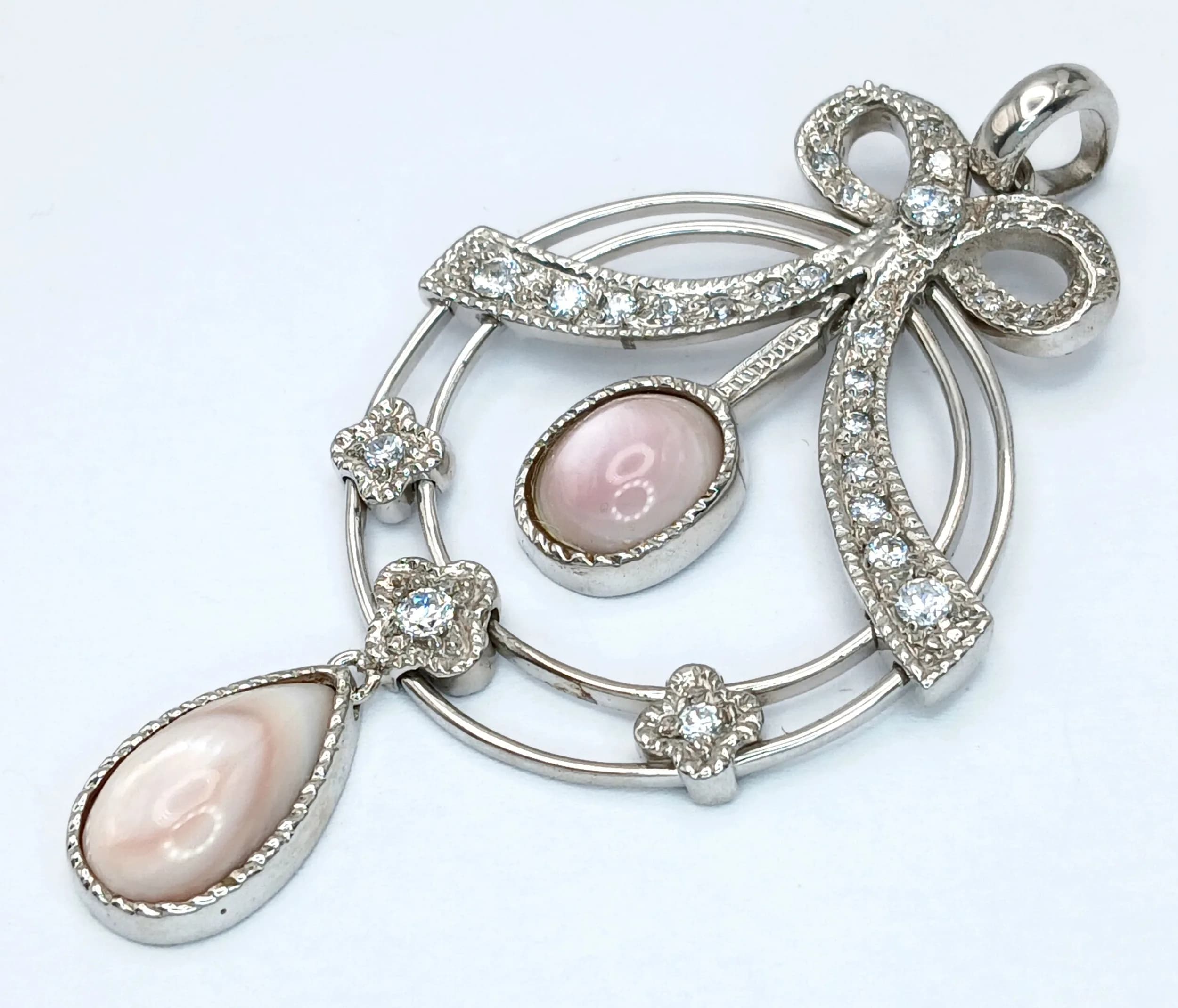 A STERLING SILVER, STONE SET, FANCY DESIGN BOW MOTIF, DROP PENDANT. 13.8G. 8429