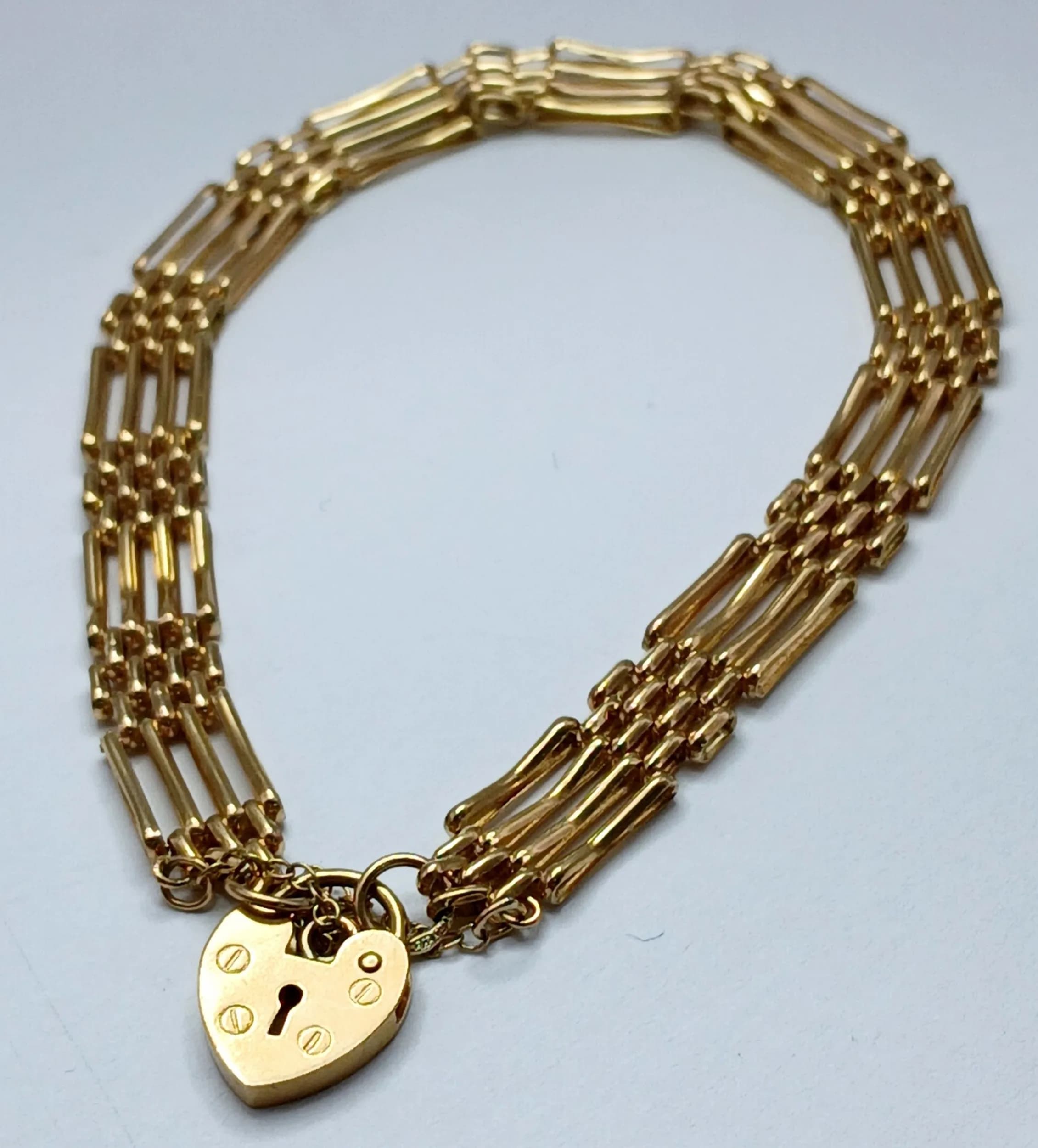 A 9K Yellow Gold Gate Bracelet with Heart Clasp and Safety Chain. 7mm width. 18cm. 5.3g. Good condition.