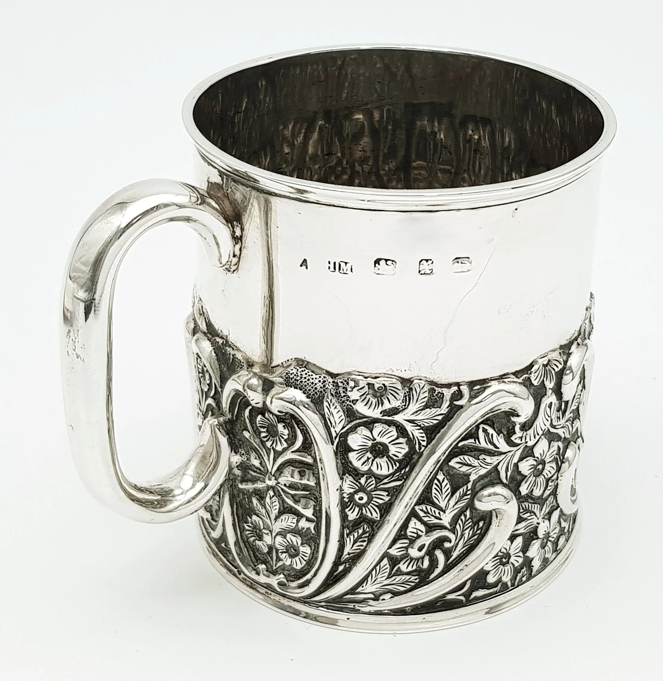 A SOLID SILVER VICTORIAN CHRISTENING CUP WITH REPOUSSE FLORAL SCROLLWORK . 115.6gms 7.5cms TALL