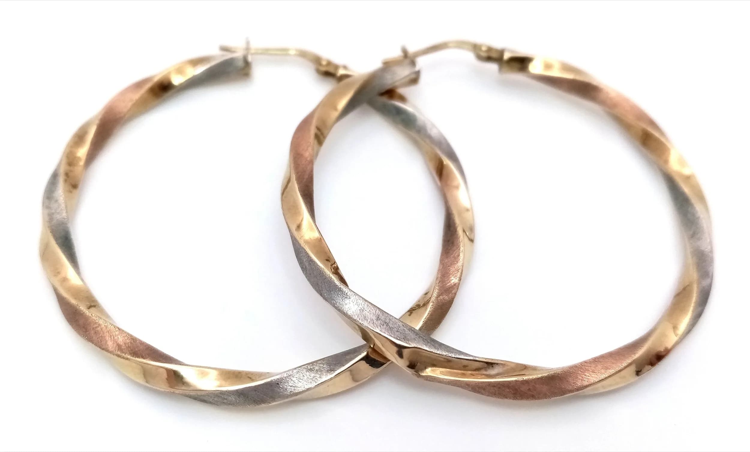 A Pair of 9K Yellow Gold Twisted Hoop Earrings. 4cm diameter. 2.2g total weight. One earring has a dent.