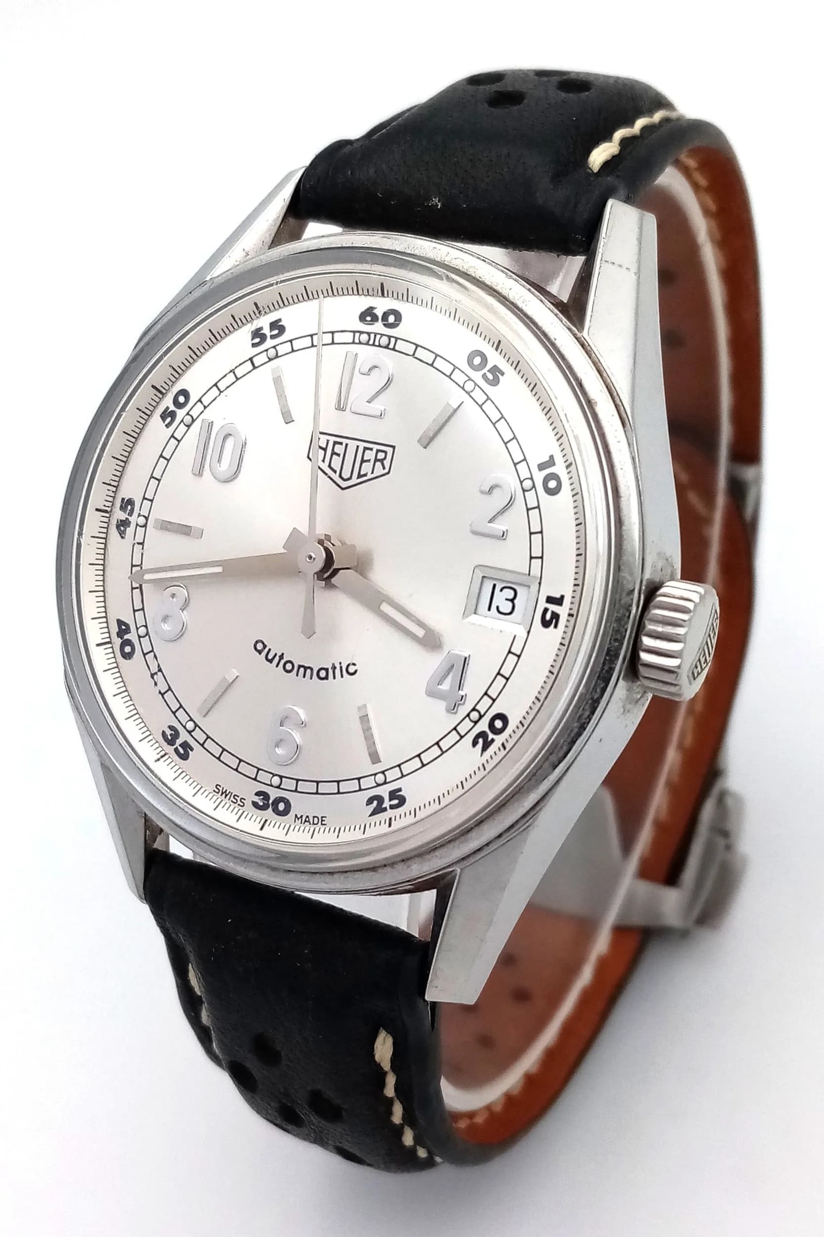 A Tag Heuer Vintage Style Re-Issue Automatic Gents Watch. Model WS2112. Black leather strap with fold-over clasp. Stainless steel case - 35mm. Silver tone dial with date window. In good condition and working order. Comes with a WCSA report. Ref: 029736.