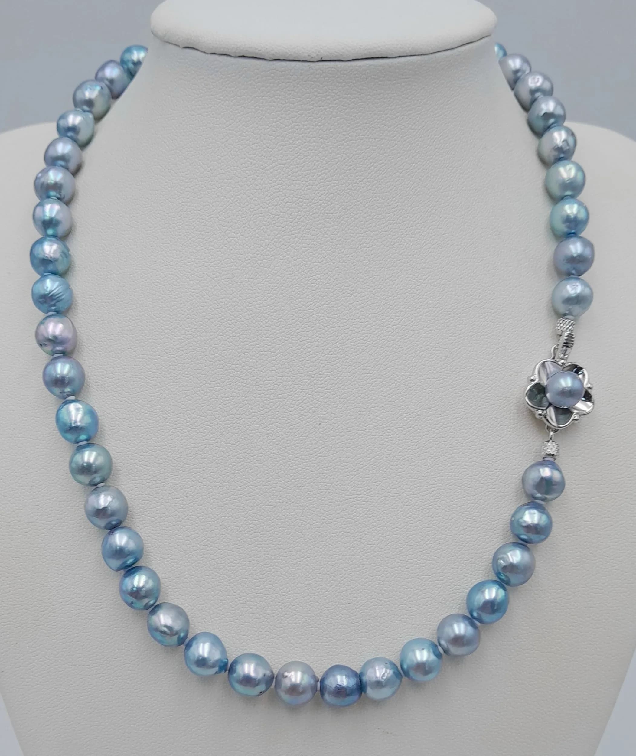 A pretty light Blue Single Strand freshwater Pearl Necklace, secured with a decorative silver tone floral clasp centred with a matching blue pearl. Approximately 43cm in length. Please see photos or request a condition report.