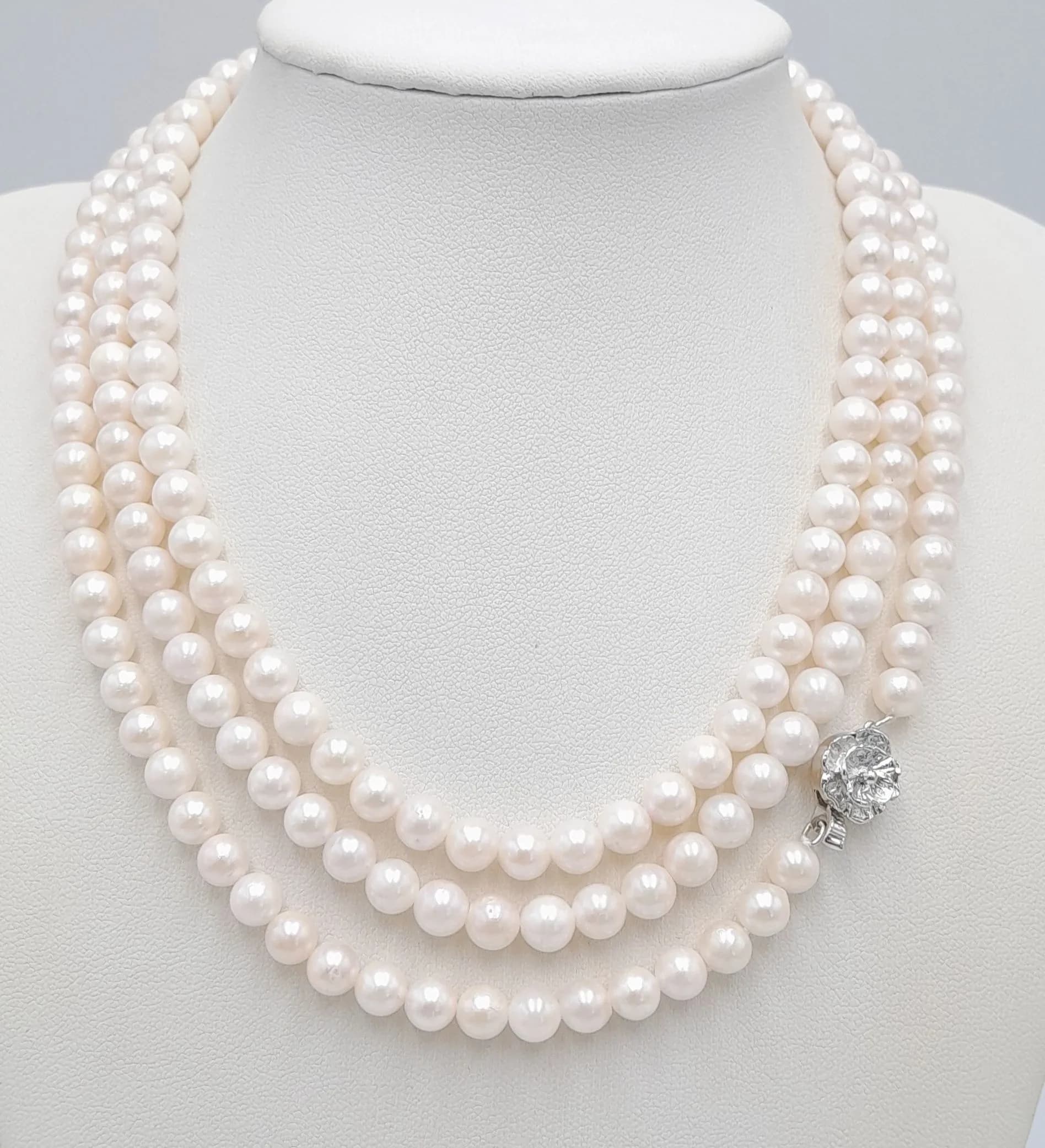A gorgeous rope length creamy white freshwater Pearl Necklace. Single strand uniform pearls with a decorative silver tone floral cluster clasp. Approximately 121cm in length. Please see photos or request a condition report.