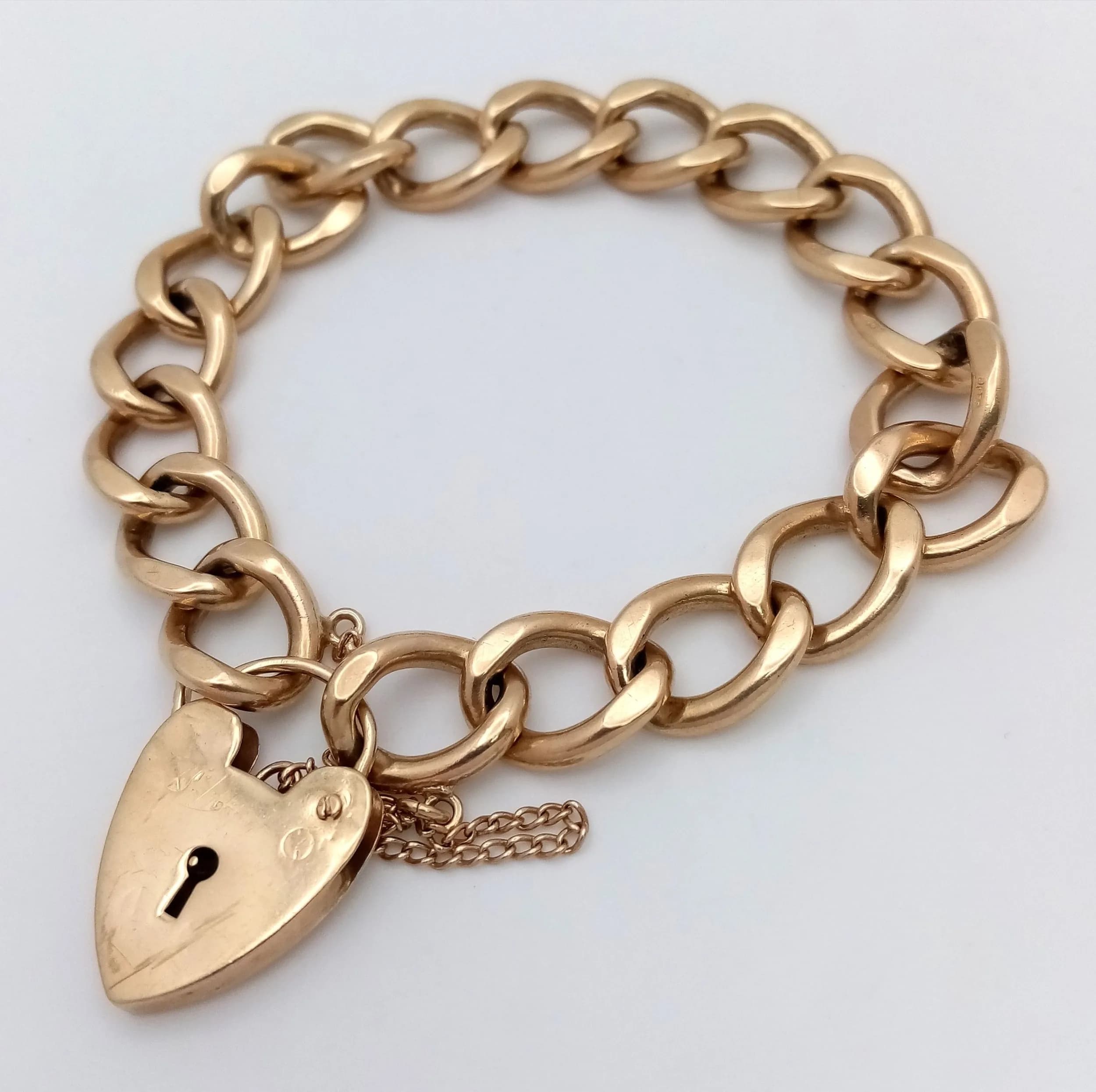 A Beautiful Chunky 9K Yellow Gold Curb Link Bracelet with Heart Clasp and Safety Chain. 17cm. 36g