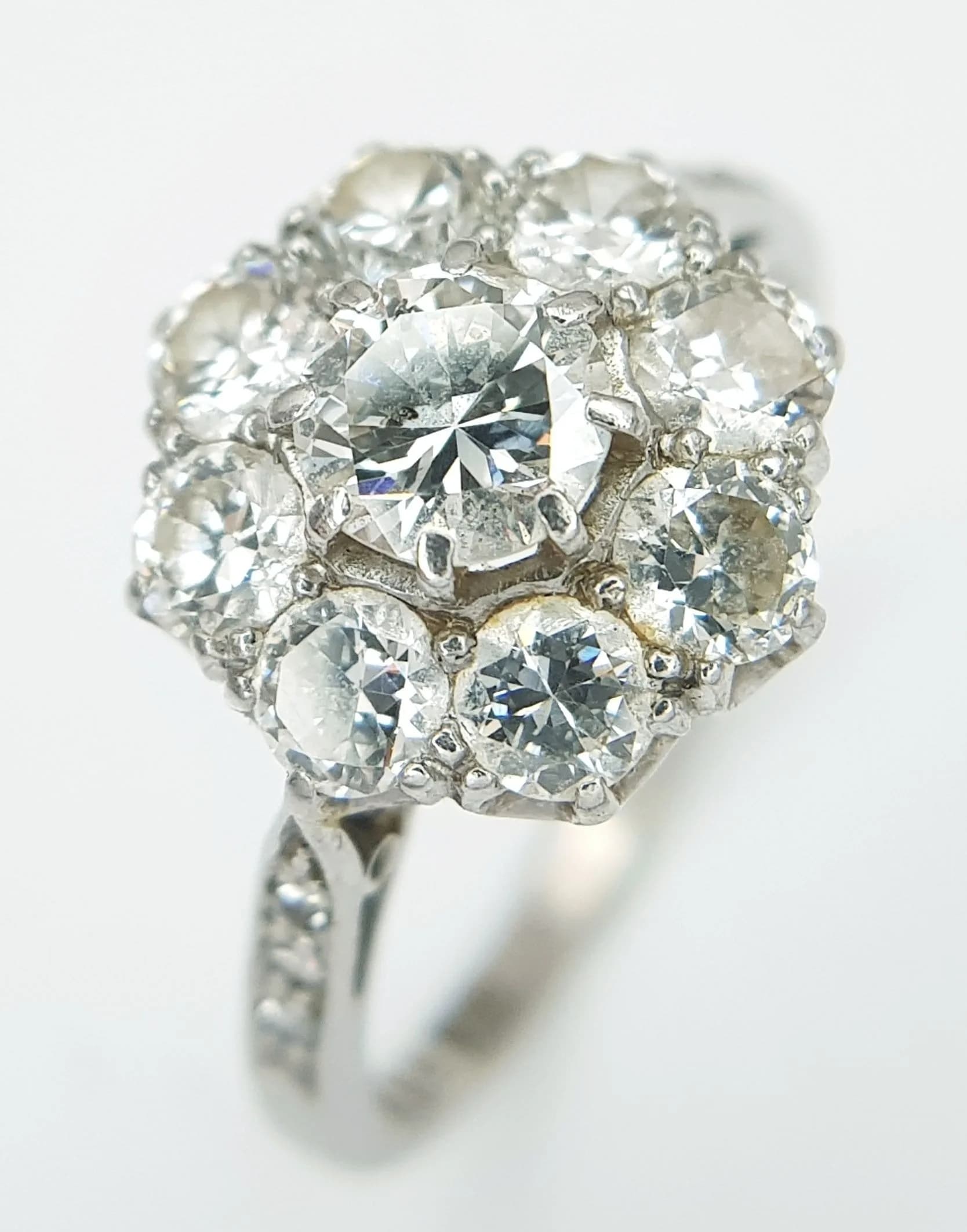 A Gorgeous Platinum Diamond Ring in Floral Form. A 0.40ct round brilliant cut centre diamond with a c. 1ctw round brilliant cut diamond surround. Diamonds having H-I colour with SI1/2 clarity. Size M 1/2. 3.55g total weight.