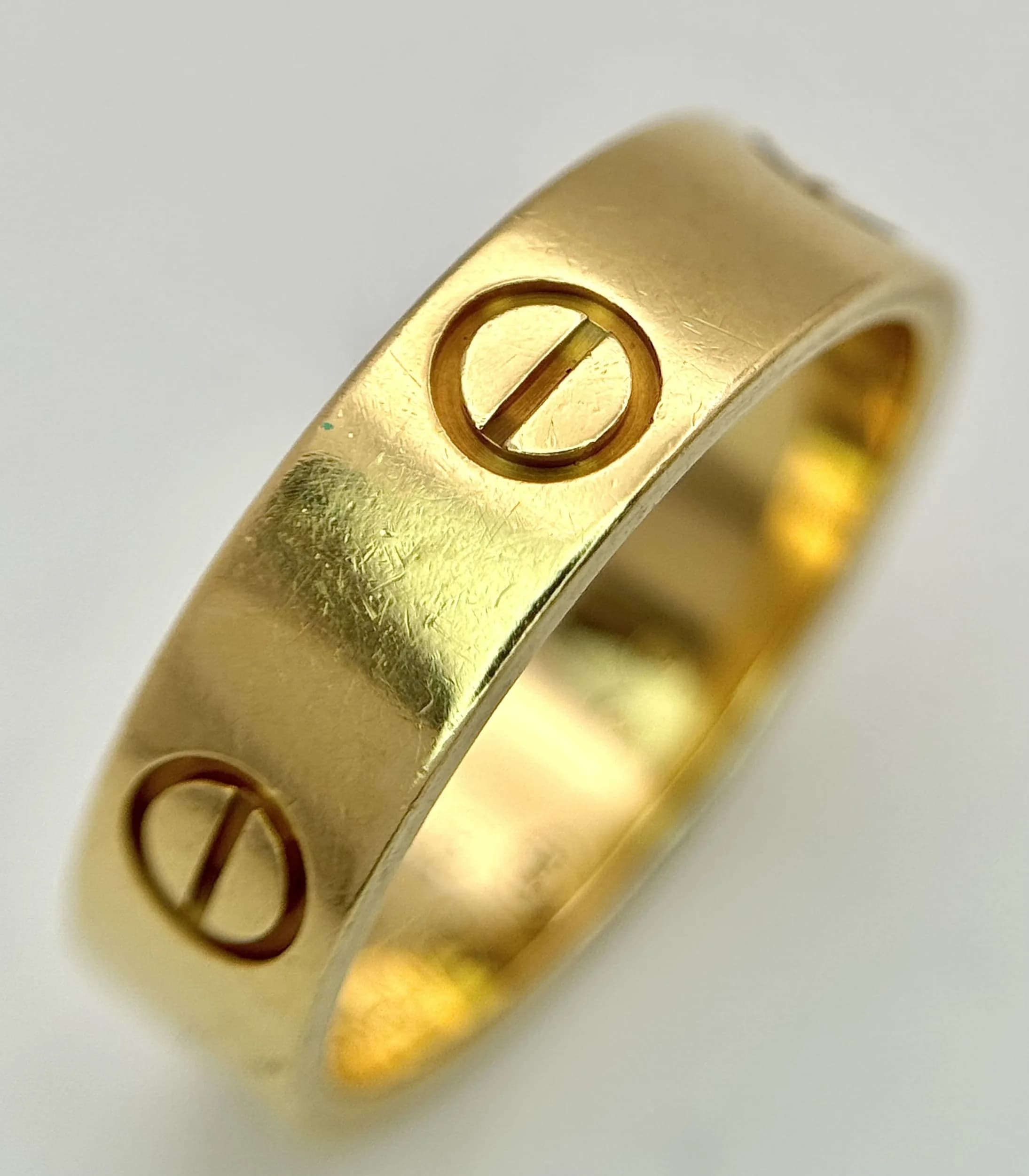 A Classic 18K Yellow Gold Cartier Love Ring. Size 56 (P). 5.5mm width. Cartier markings on inner band. Comes with case, box and certificate. 6.3g. Ref: 029692.