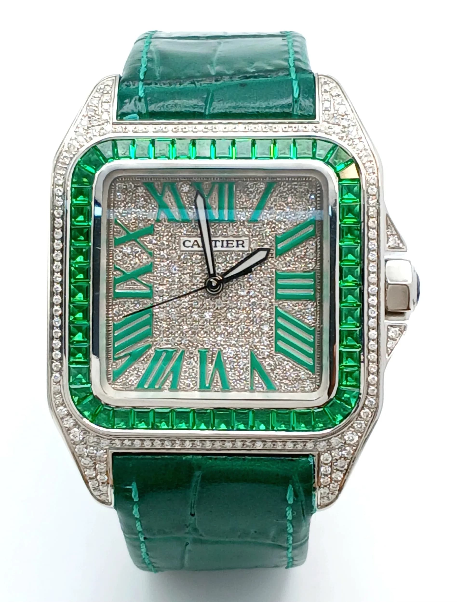 A Cartier Santos 100 Diamond and Emerald 'Hulk' Automatic Gents Watch in Cartier box. Green leather strap with diamond set clasp. Diamond encrusted dial with green Roman numeral markers. Emerald set inner bezel with a diamond set outer that extends to the case sides and lugs. Sapphire crown. Note: This watch has been professionally custom fitted with Natural diamonds and Lab emeralds. In very good condition and working order.