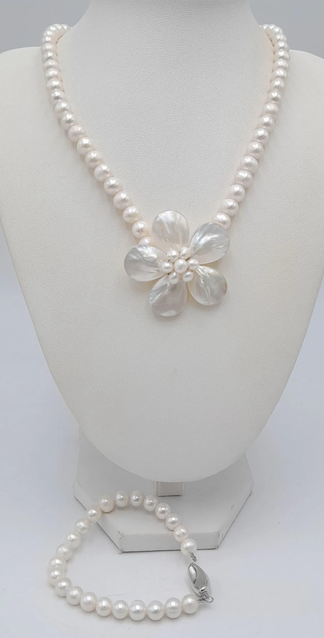 A pretty creamy white freshwater pearl Necklace with Mother of Pearl Flower Pendant and Matching Bracelet set. Approx. 46.5cm necklace length and 18.5cm bracelet length. Please see photos or request a condition report.