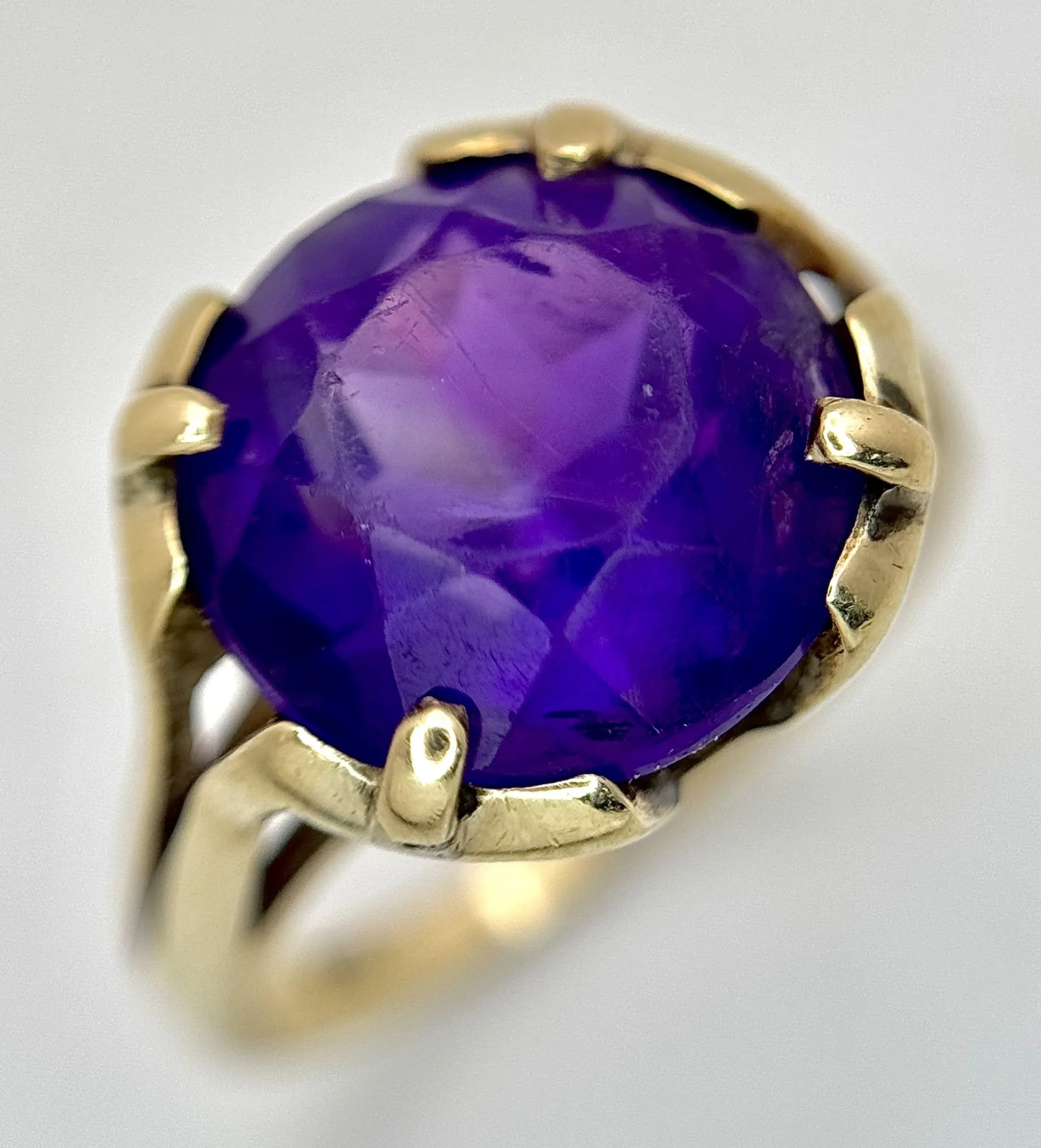 A 9K Yellow Gold and Amethyst Cocktail Ring. A 6ct round cut amethyst in a claw setting. Size N 1/2. 4.27g total weight.