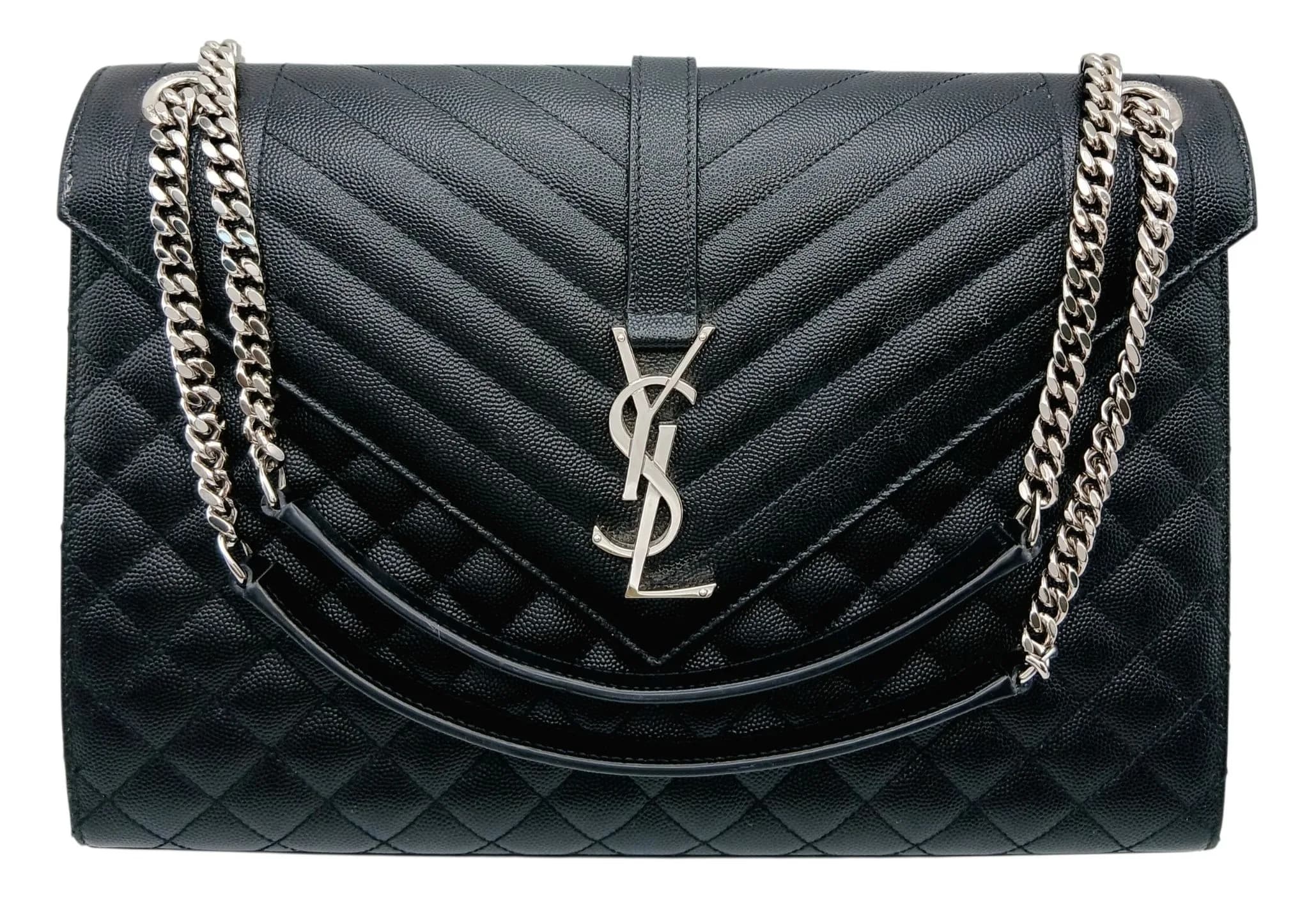 A Black Saint Laurent Grain De Poudre Textured Mixed Matelassé Triquilt Medium Monogram Satchel Bag. Black grained leather exterior with silver-tone hardware, silver-tone chain shoulder strap with leather shoulder pad, rear exterior flat pocket, and envelope-style flap with a signature YSL monogram magnetic closure. Black textile interior with one main compartment and one zipped inner side pocket. Approx. 31.3cm length x 22.2cm height x 7.3cm depth. Very light signs of wear to the corners and light stains to the interior. Please see photos or request a condition report. Ref: 28184.