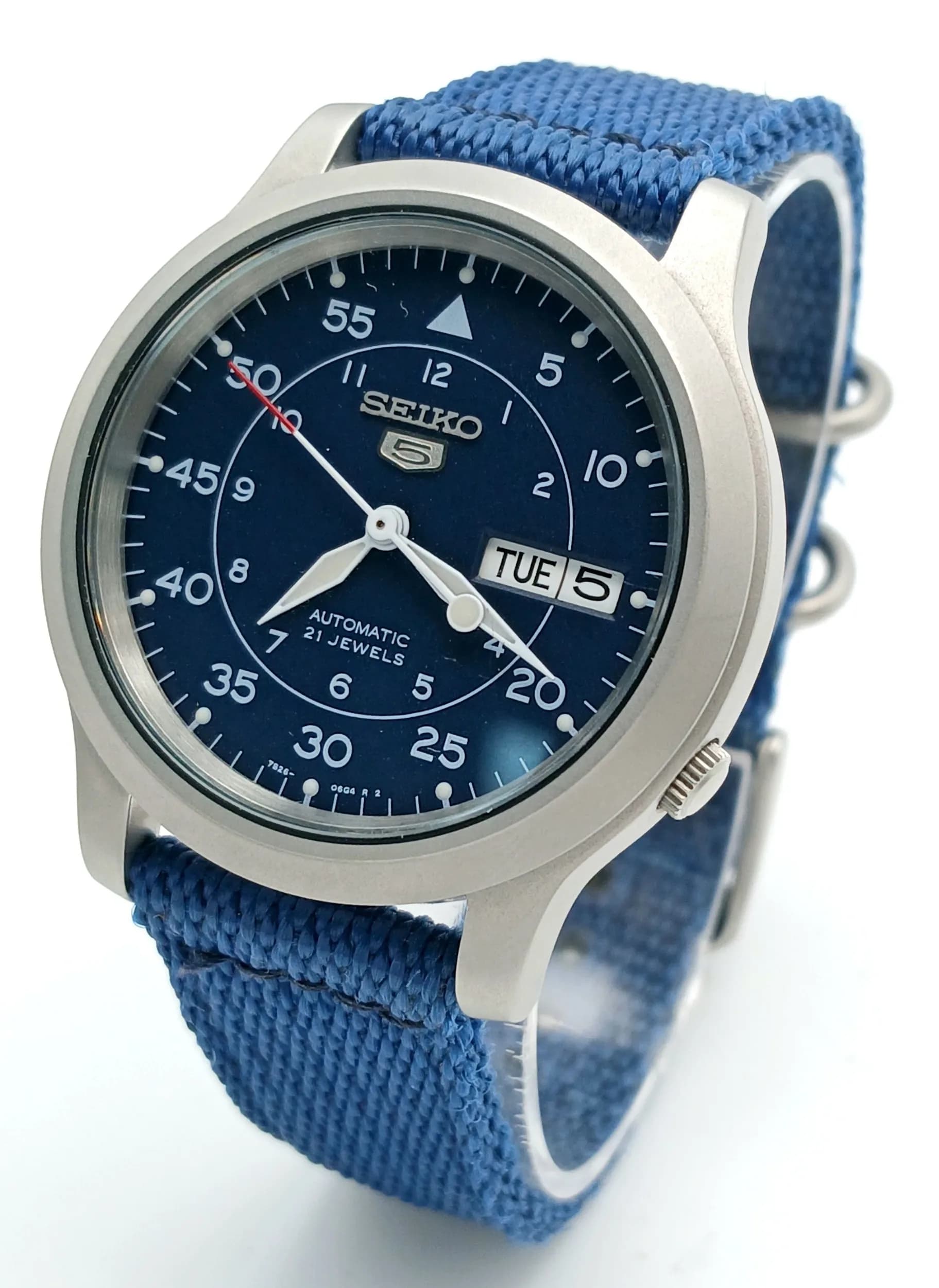 A Seiko 5 Automatic Gents Watch. 21 jewels. Model - 7S26C. Blue cloth strap. Stainless steel case - 38mm. Skeleton back. Blue dial with day/date window. In working order.