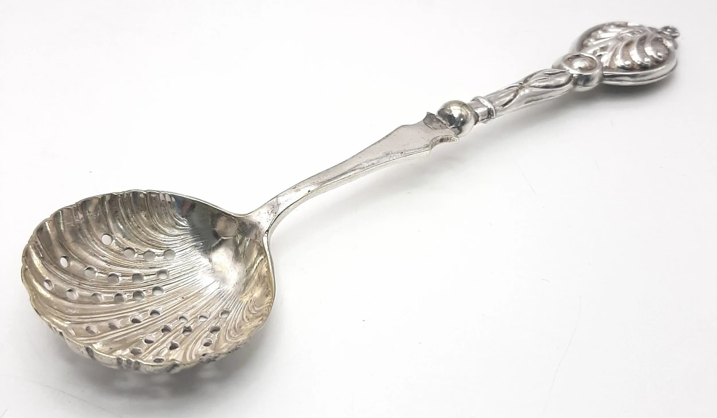 A Birmingham Hallmarked Silver Sifter Spoon. Shell shaped pierced bowl with decorative embossed handle. Hallmarked Birmingham 1904. Approx 17cm length. Total weight 27.05 grams.